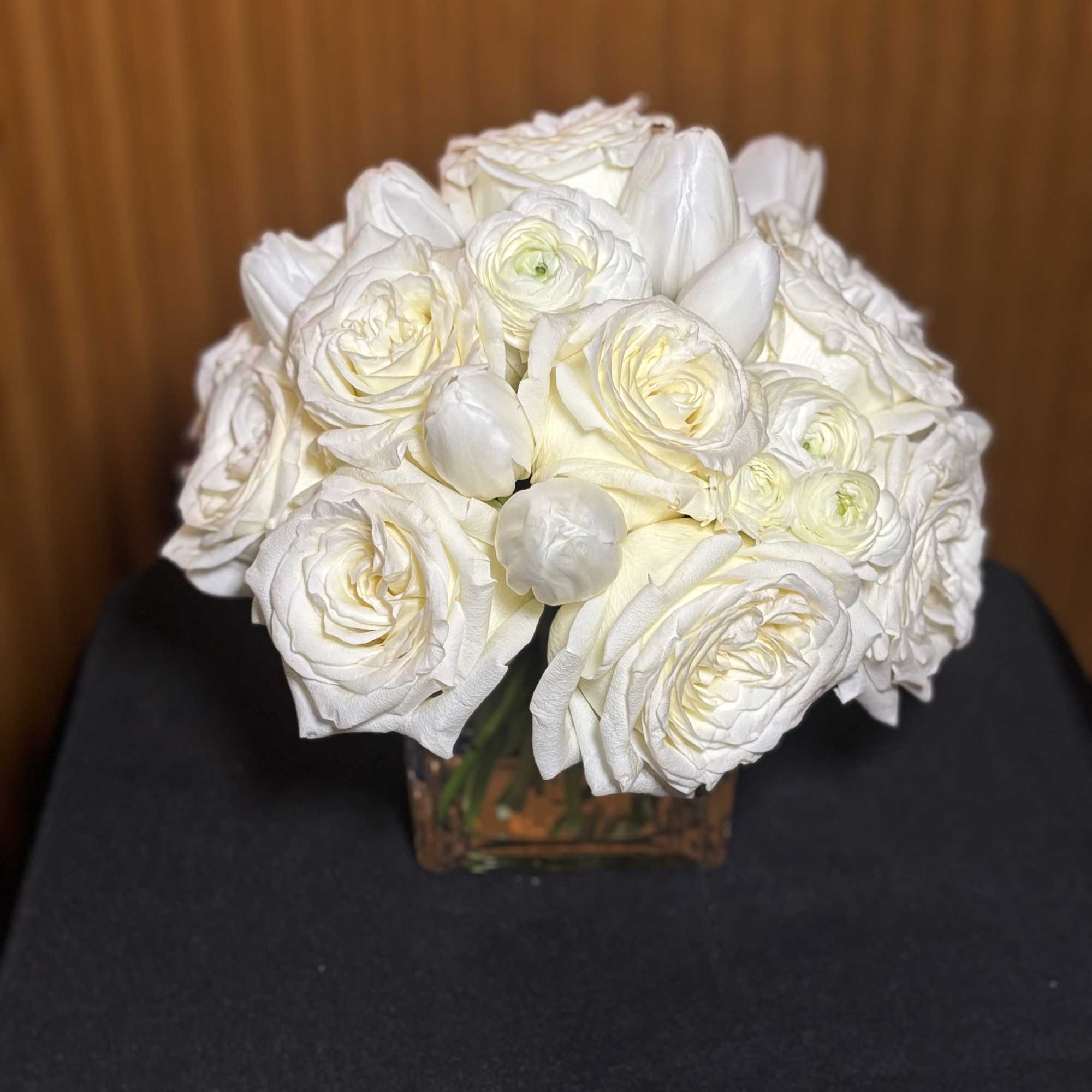 White rose and ranunculus bouquet in a square glass vase