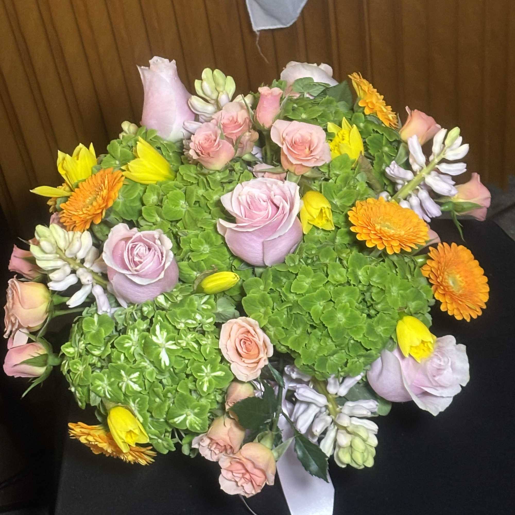 Bouquet of pink roses, green hydrangeas, and orange daisies with yellow tulips