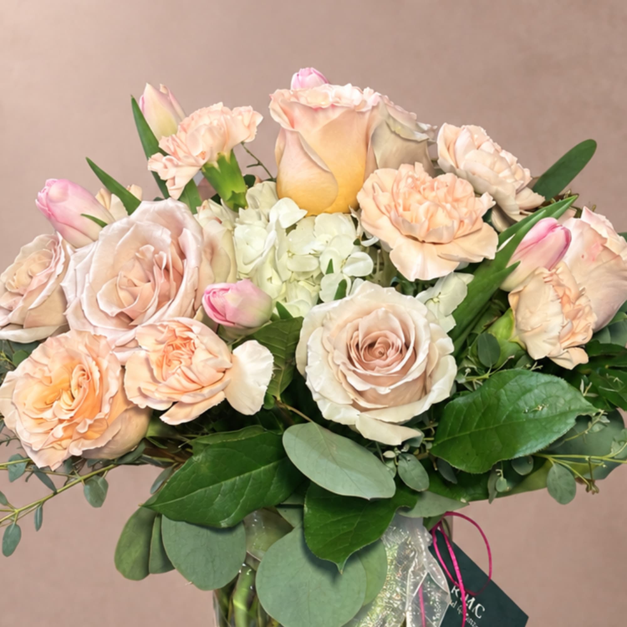 Peach and blush roses with pink tulips in a bouquet