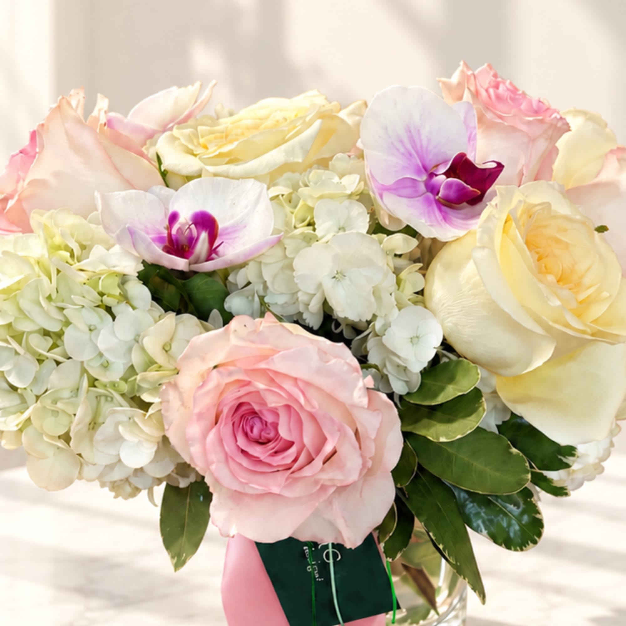 Bouquet of pink and cream roses with white orchids and hydrangeas