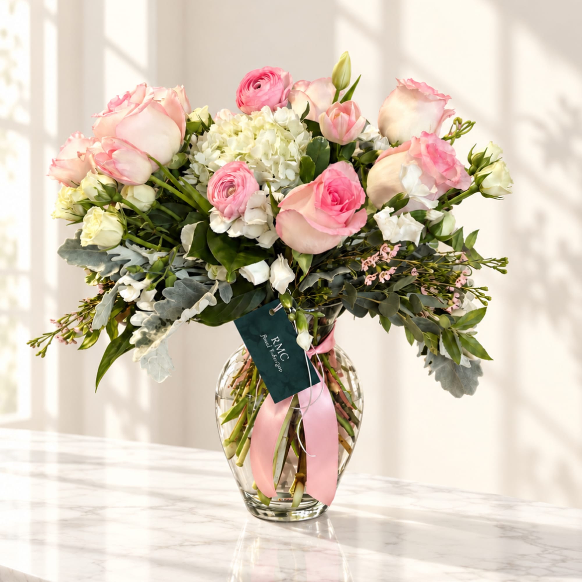 Pink and white rose bouquet in a clear glass vase