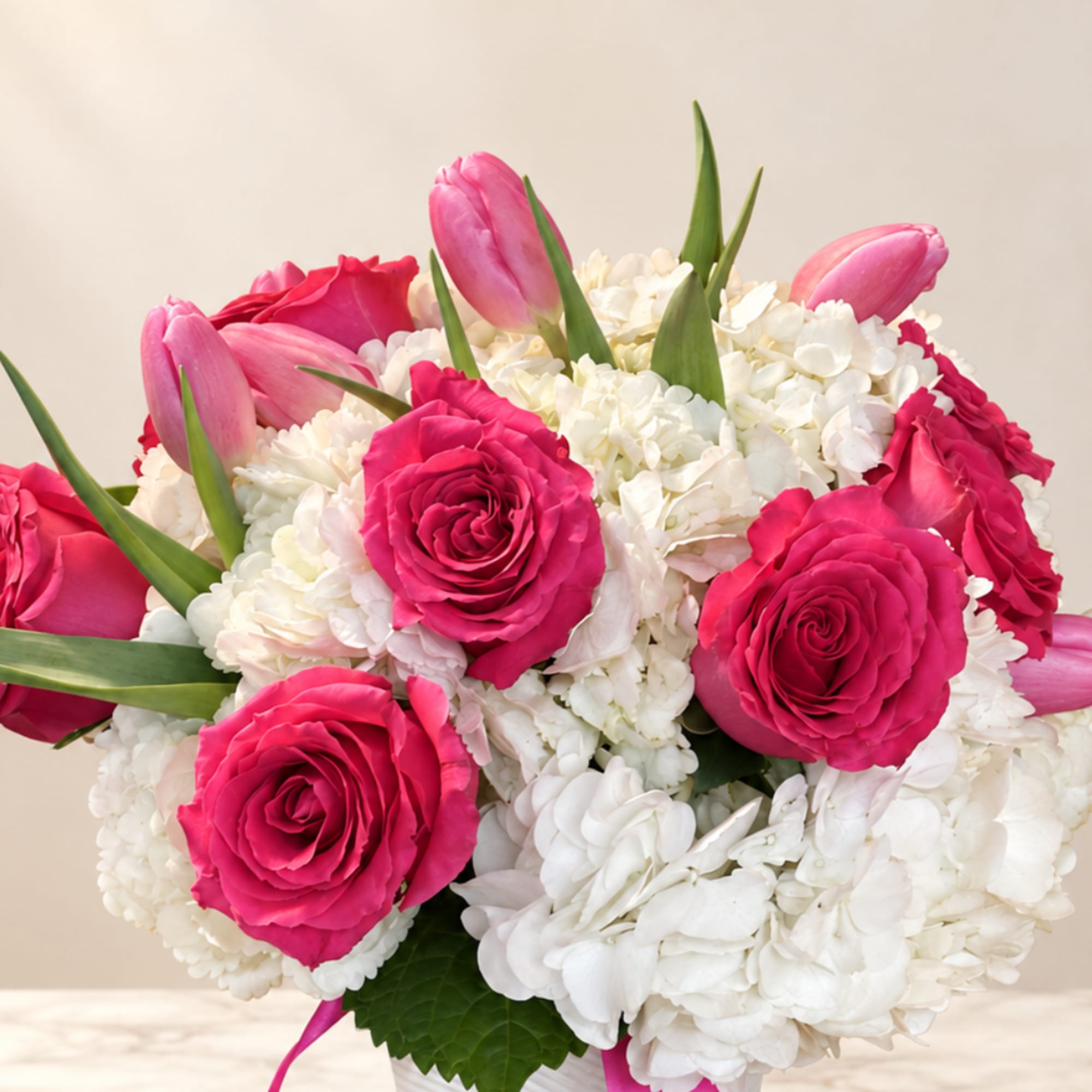 Pink roses and tulips in a white hydrangea bouquet