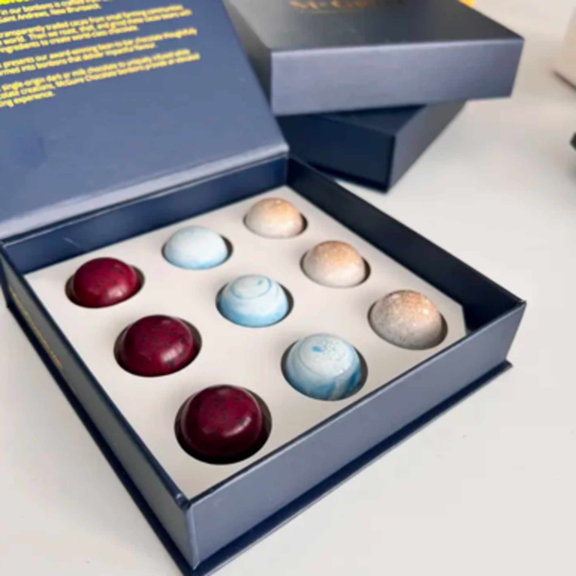 Box of assorted dome-shaped chocolates in blue and burgundy