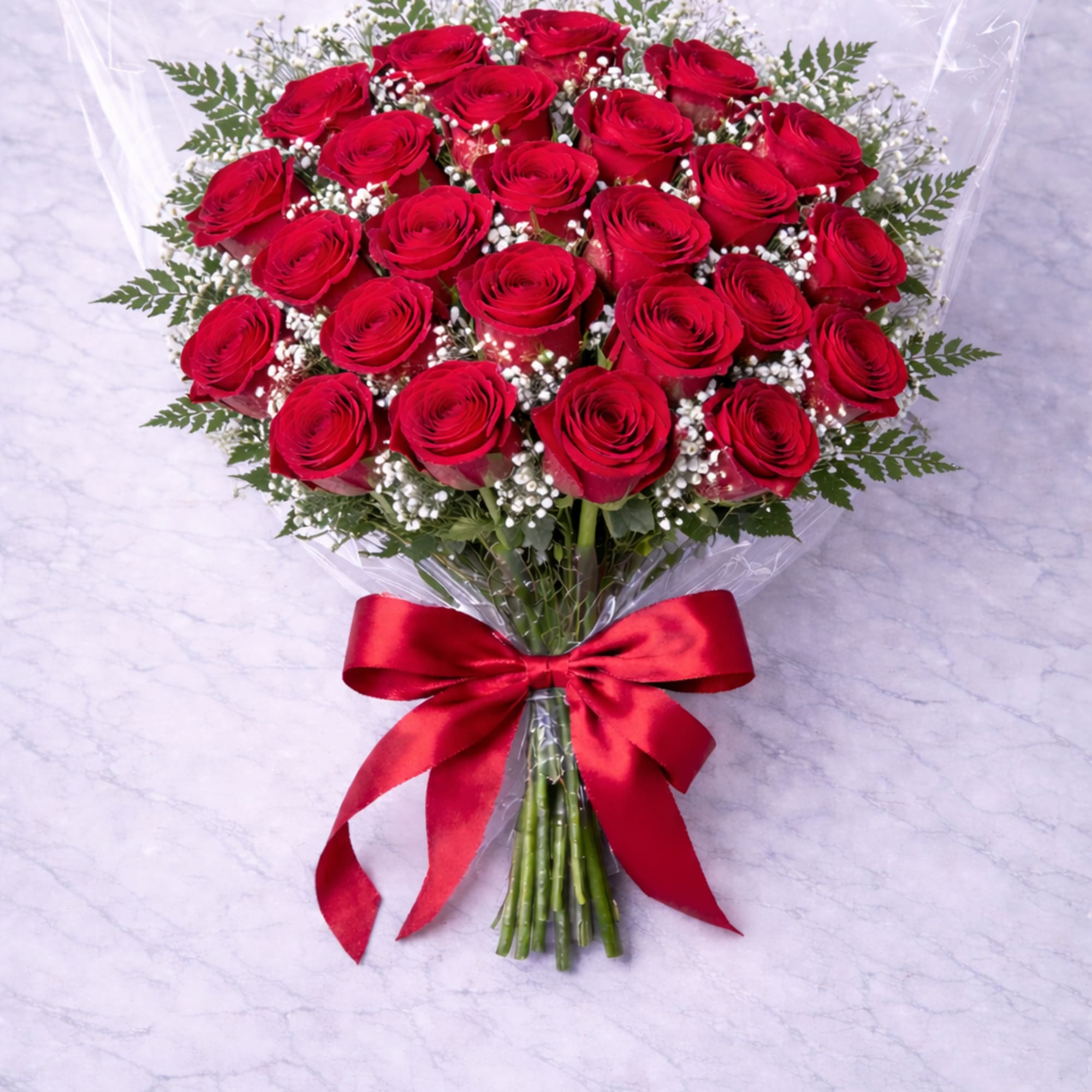 Bouquet of red roses wrapped in clear plastic with a red ribbon