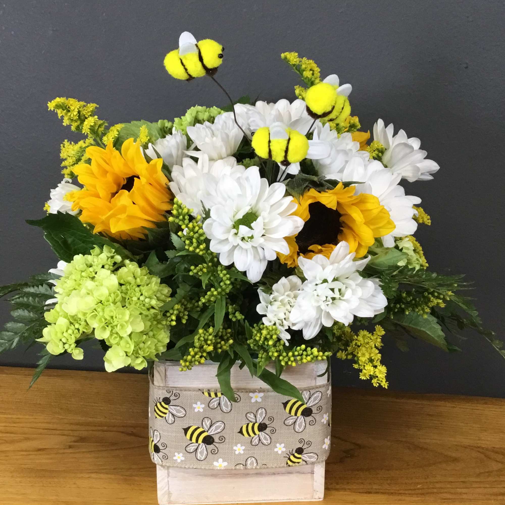 Golden sunflowers and lavender roses create an instant smile in this Bee