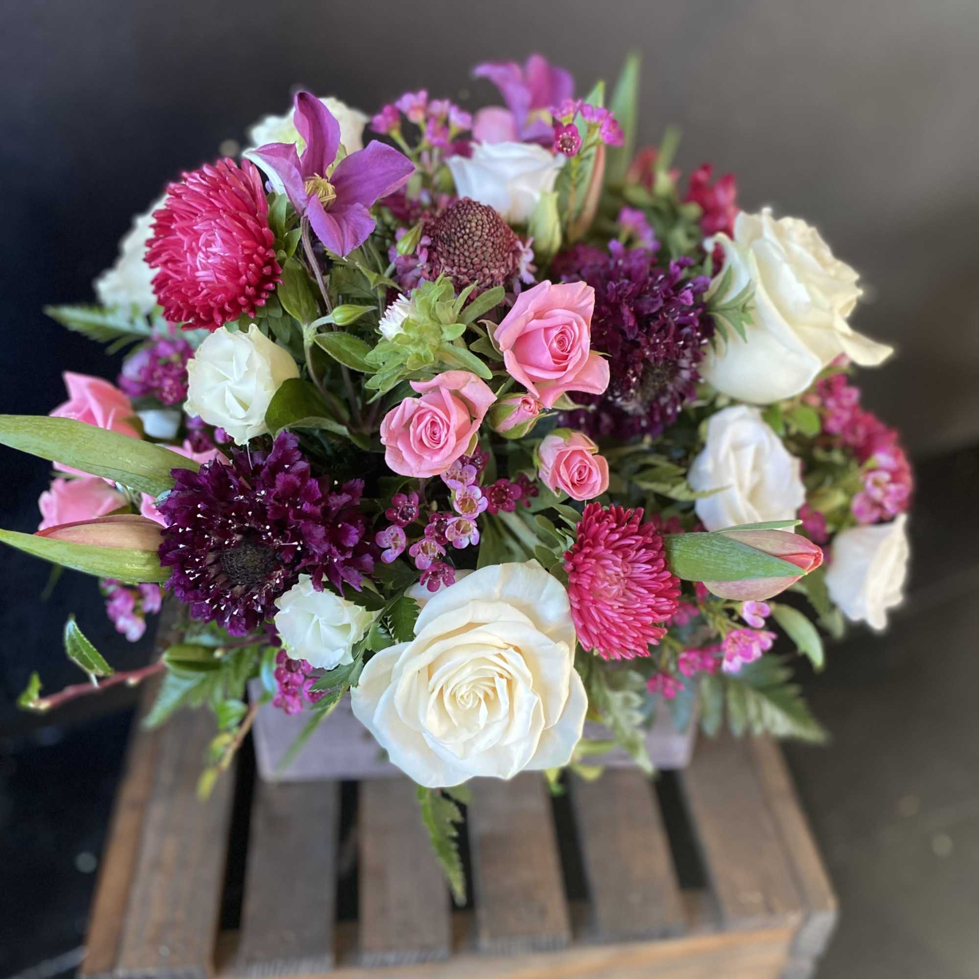 Mixed pink and white flower bouquet in a wooden crate