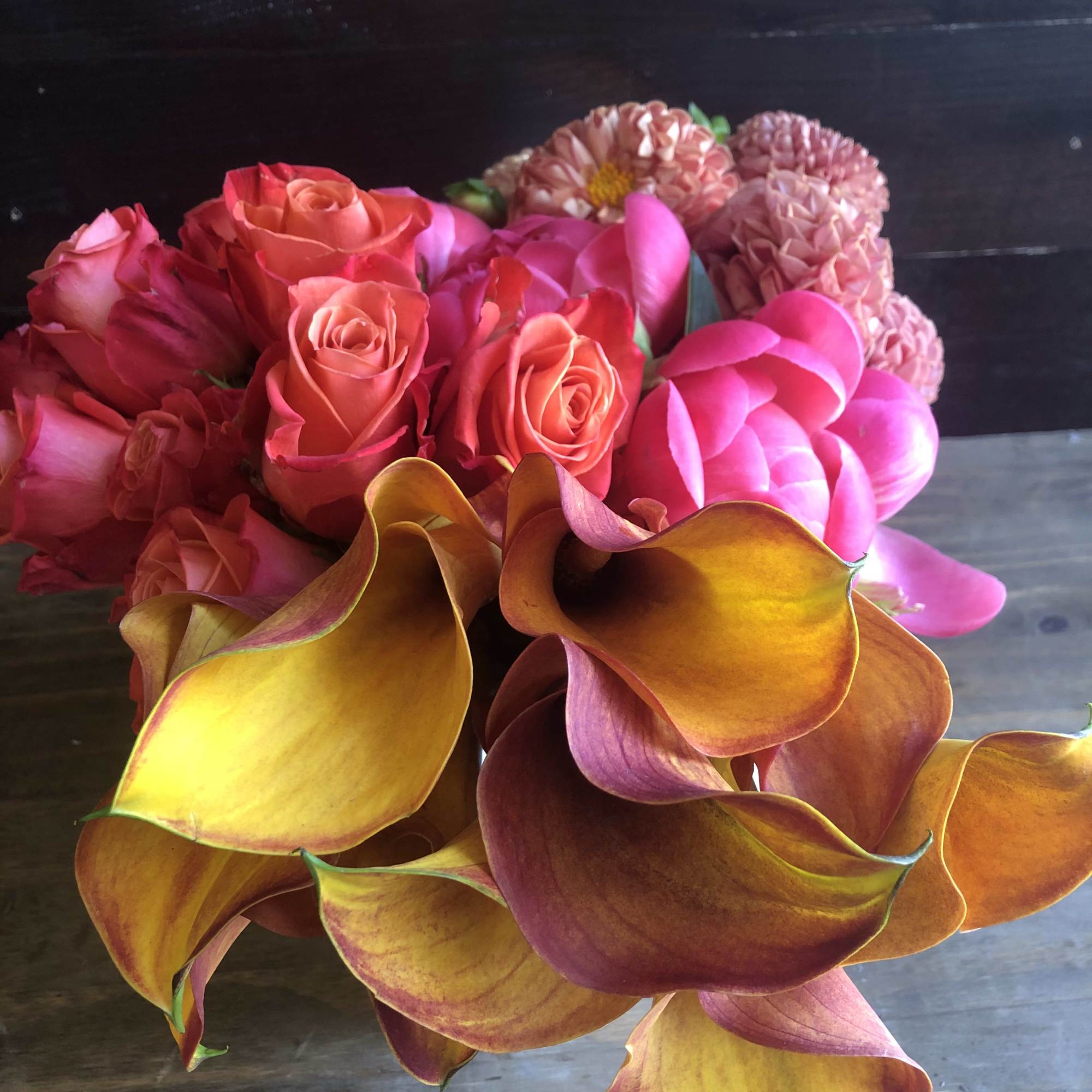 Bouquet of pink roses, calla lilies, and round pink blooms