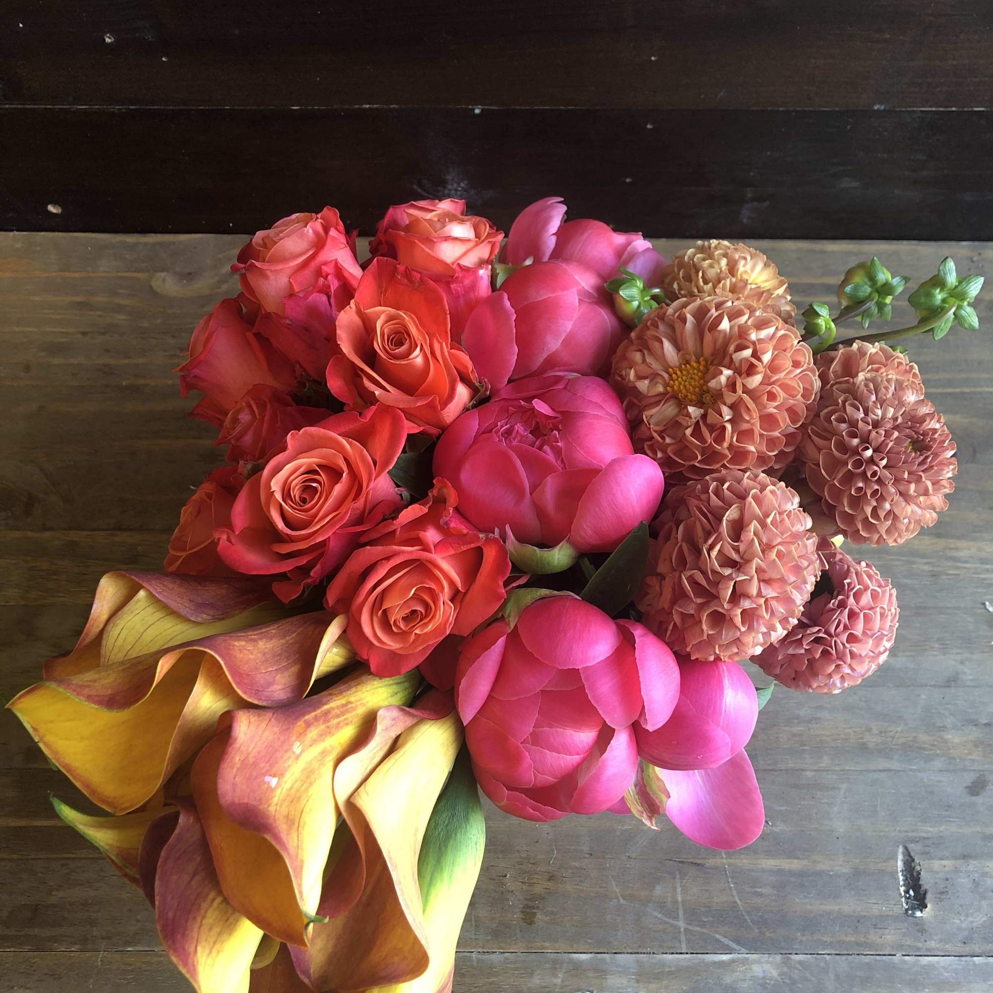 Bouquet of pink roses, peonies, calla lilies, and peach dahlias