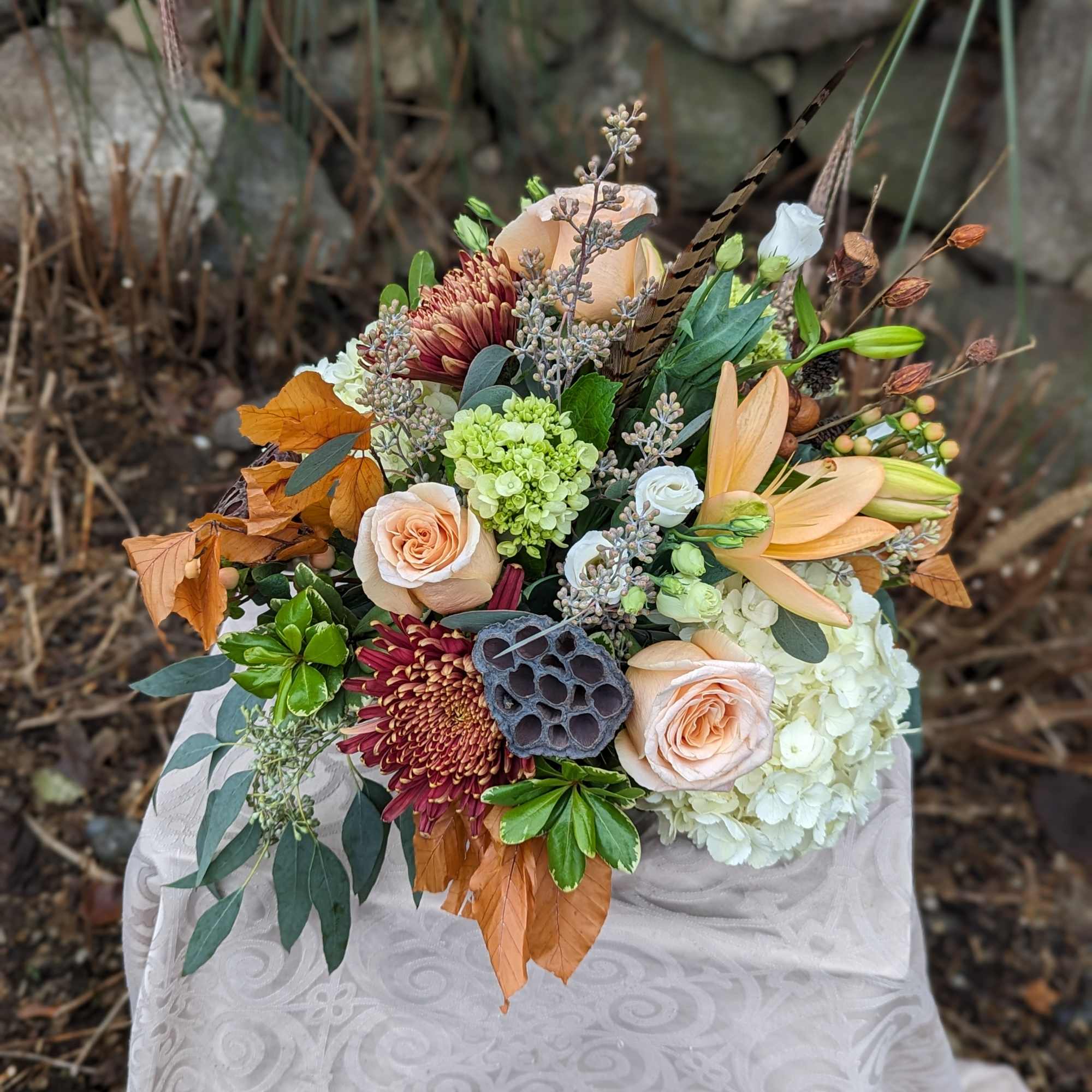 Peach and burgundy bouquet with hydrangea, roses, and lilies