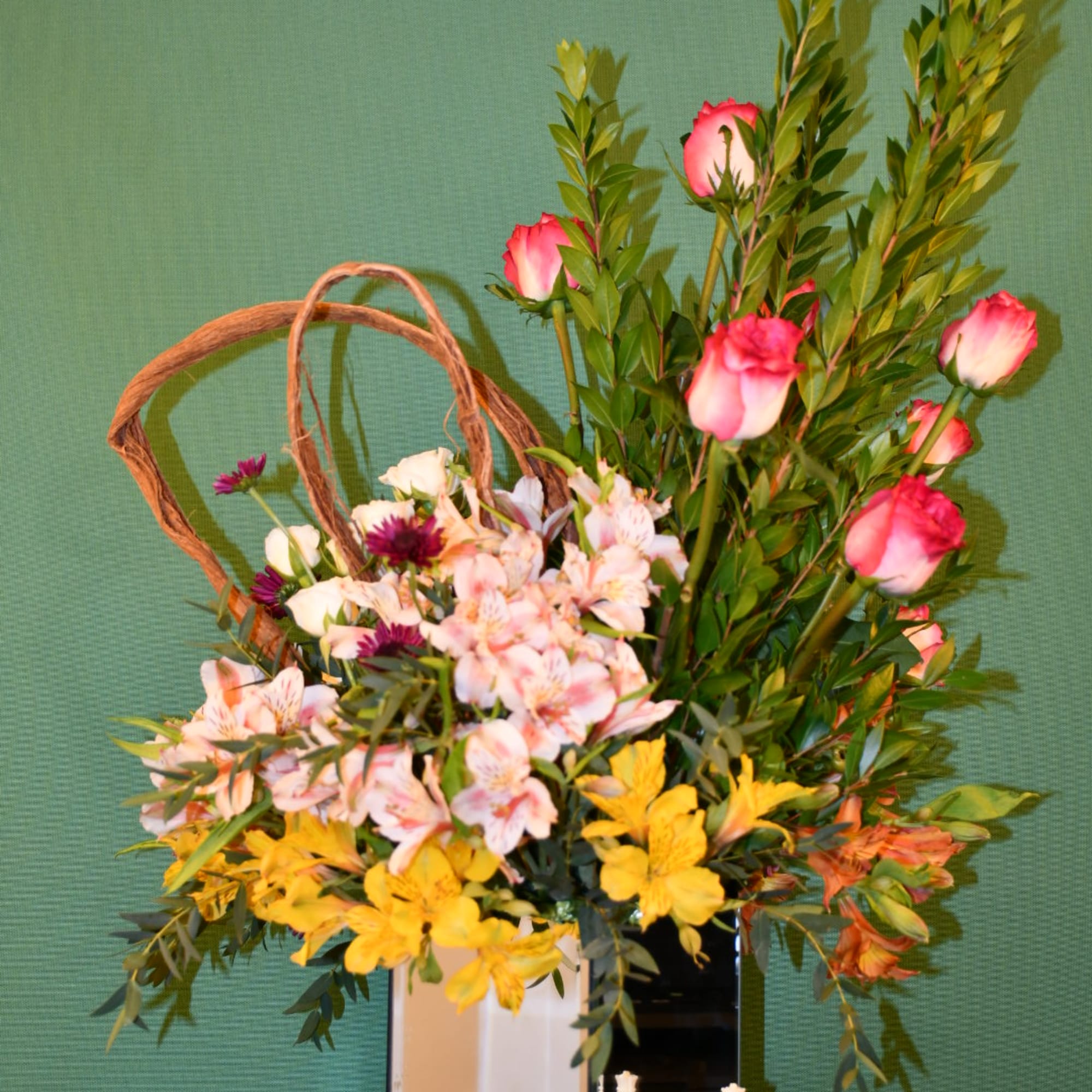 Mixed bouquet with pink roses, alstroemeria, and yellow flowers in a vase