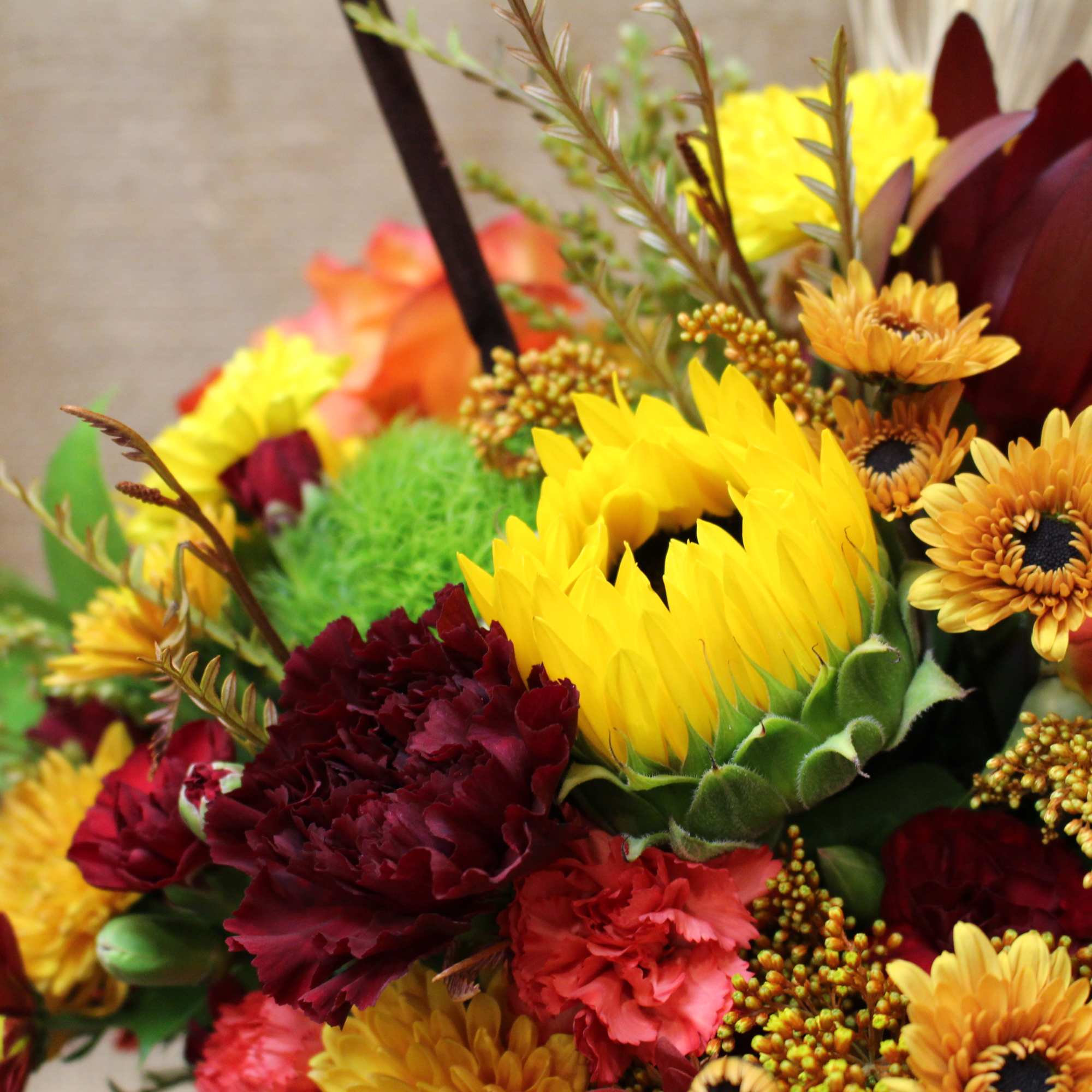 Mixed bouquet with sunflowers, roses, and burgundy blooms