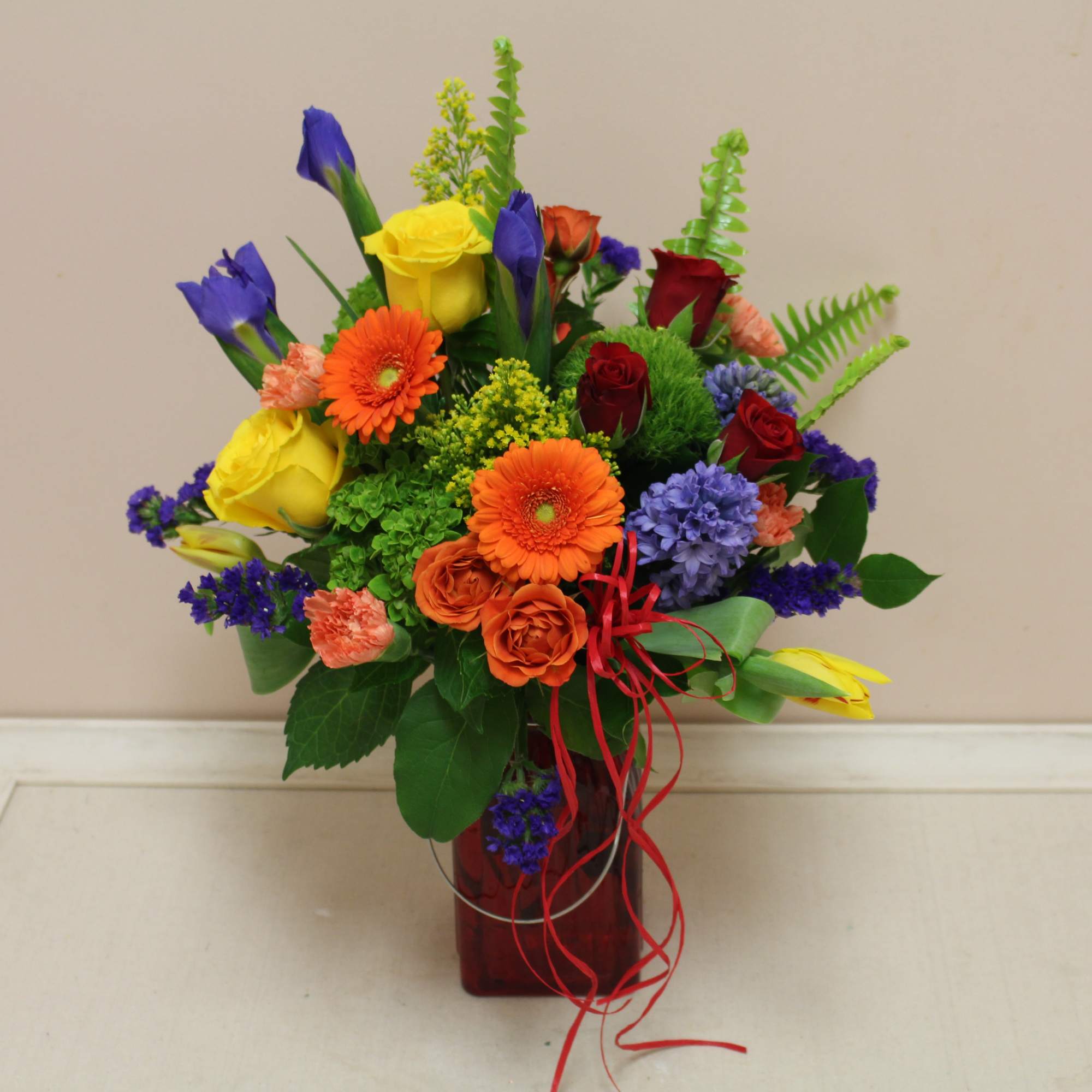 Colorful mixed bouquet in a red glass vase
