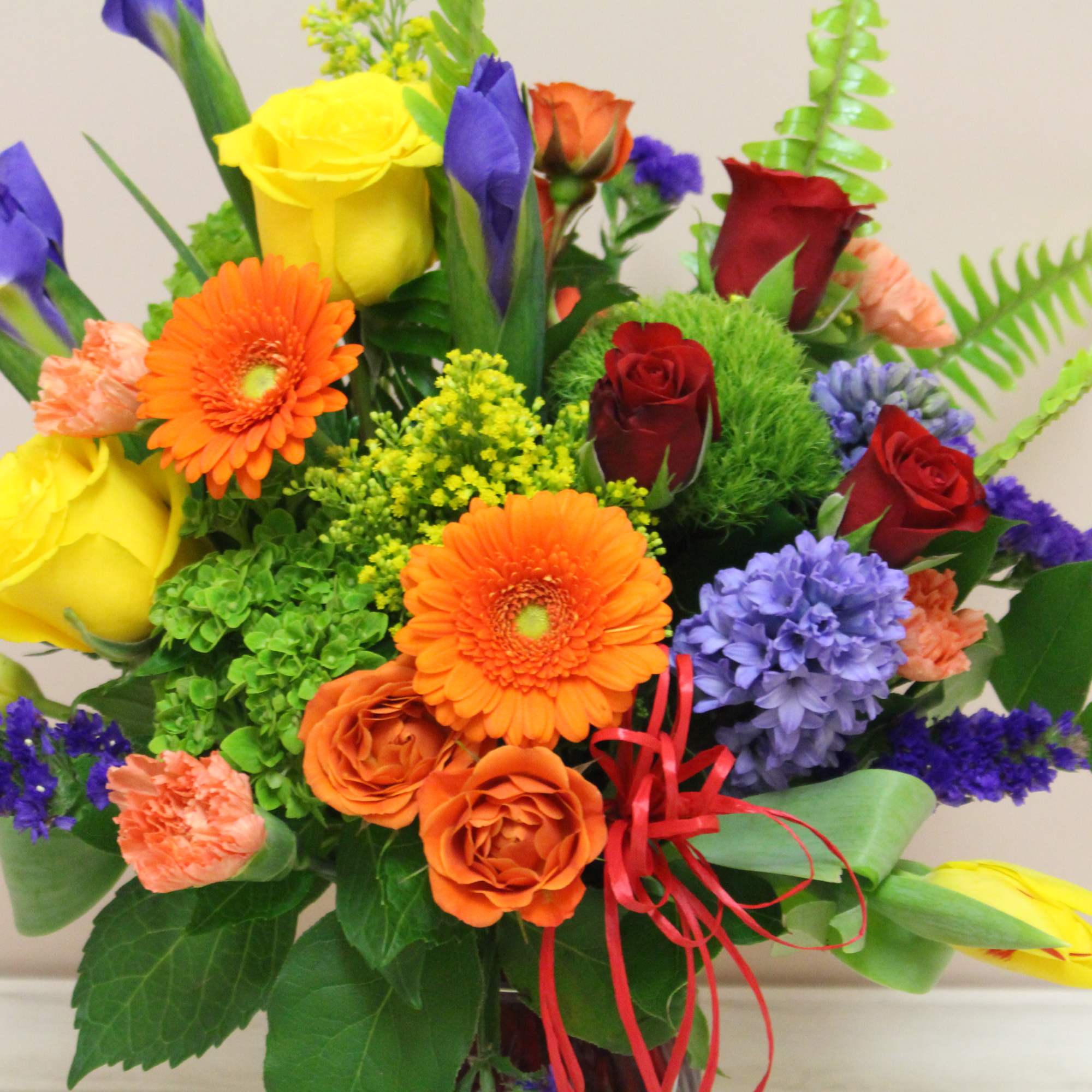 Colorful mixed bouquet with roses, gerbera daisies, and purple blooms