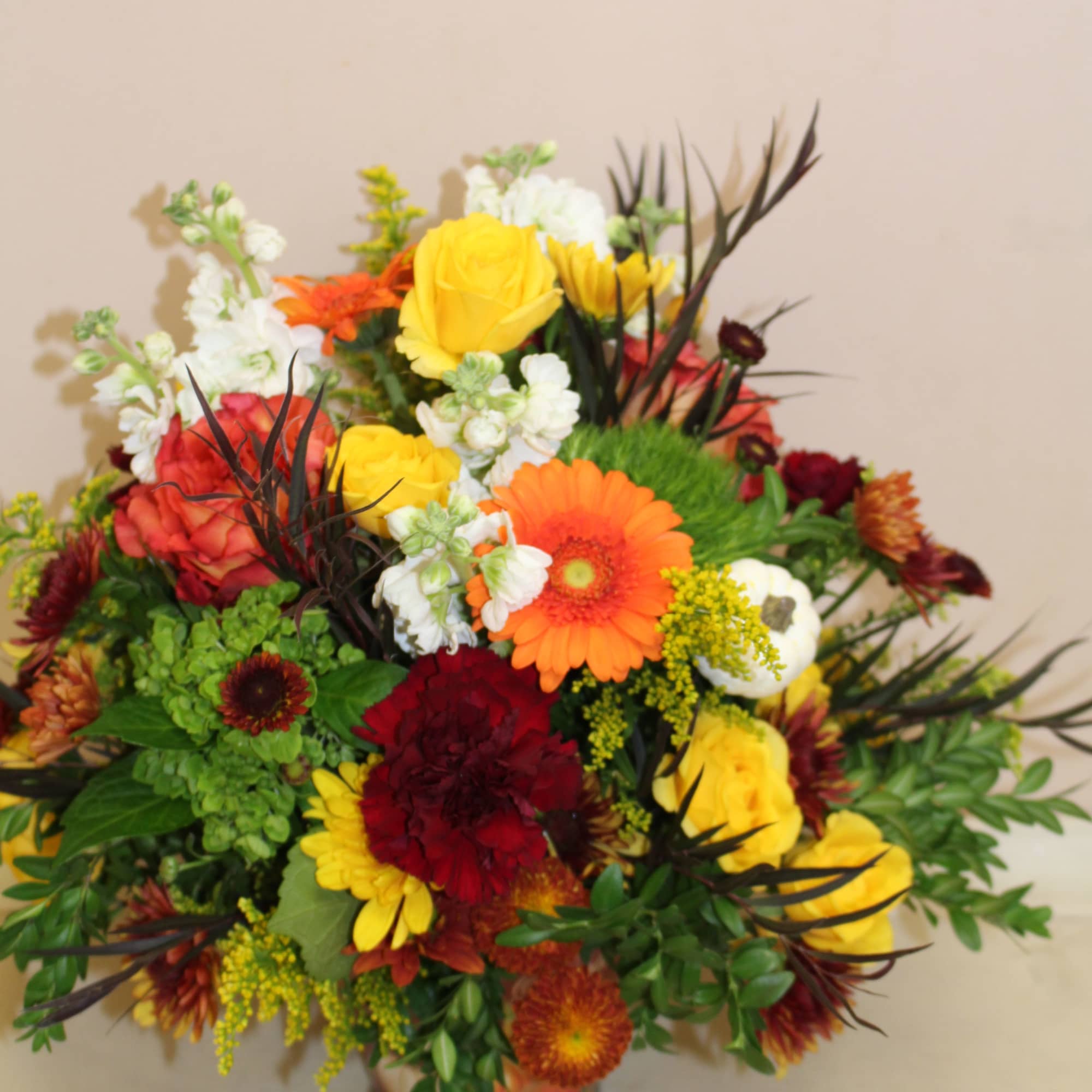 A festive autumn arrangement filled with an array of flowers including gerberas