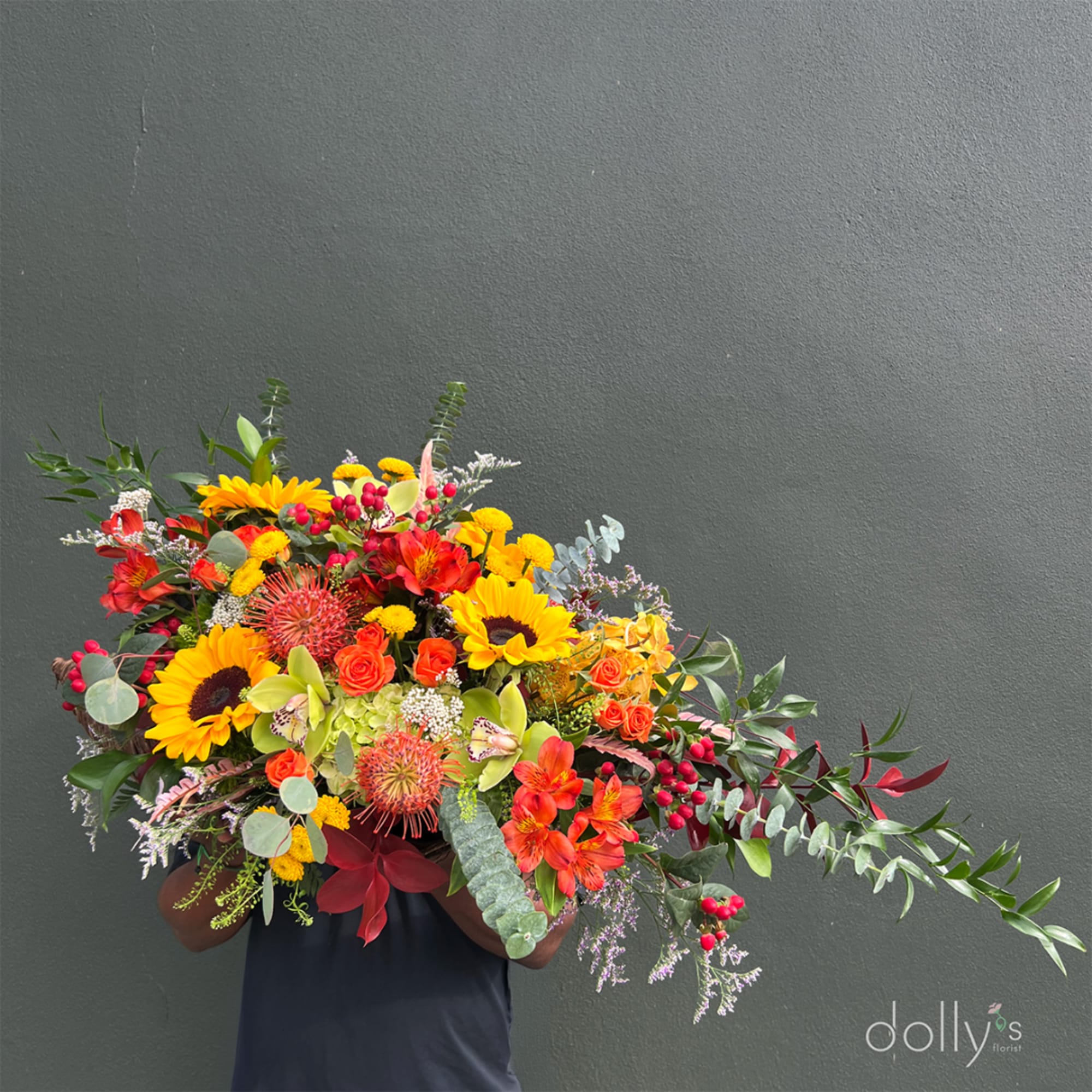 Large bouquet with sunflowers, orange roses, and red tropical blooms