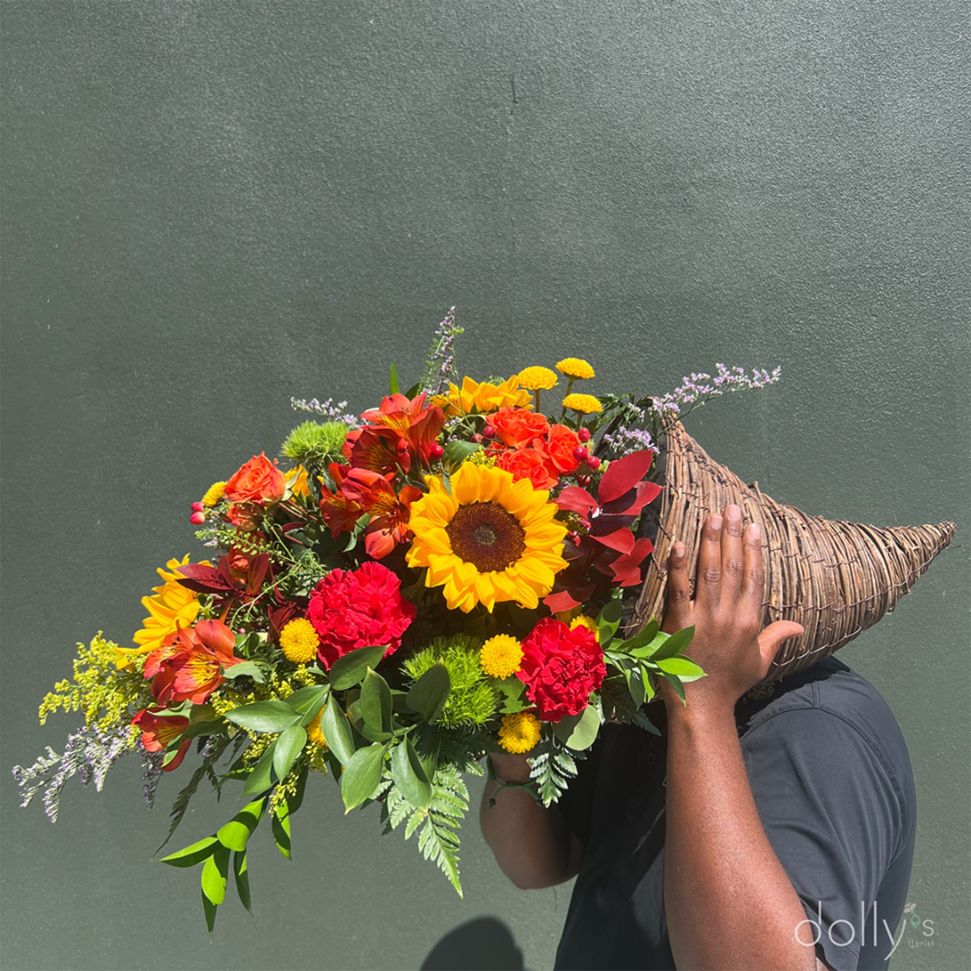 Large colorful bouquet in a woven cone wrap held by a person