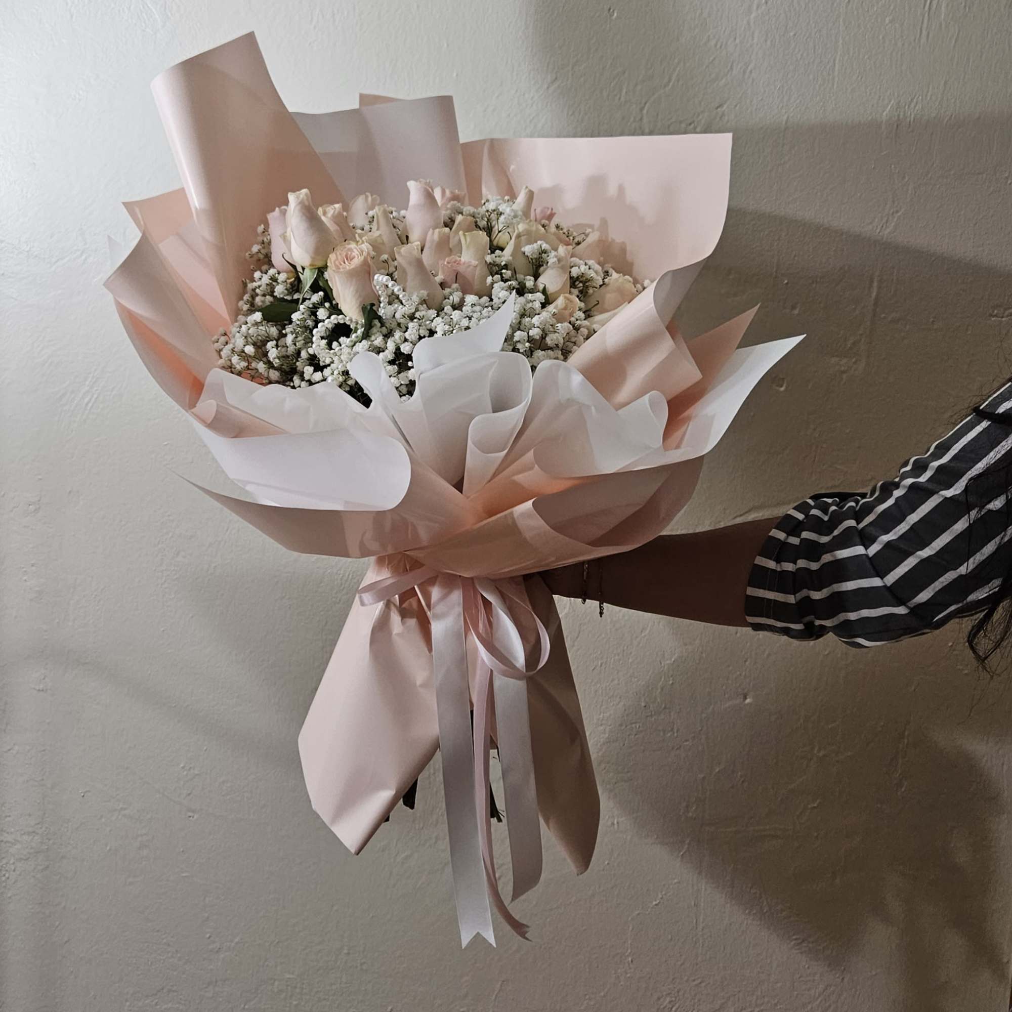 Bouquet of pale pink roses wrapped in blush paper