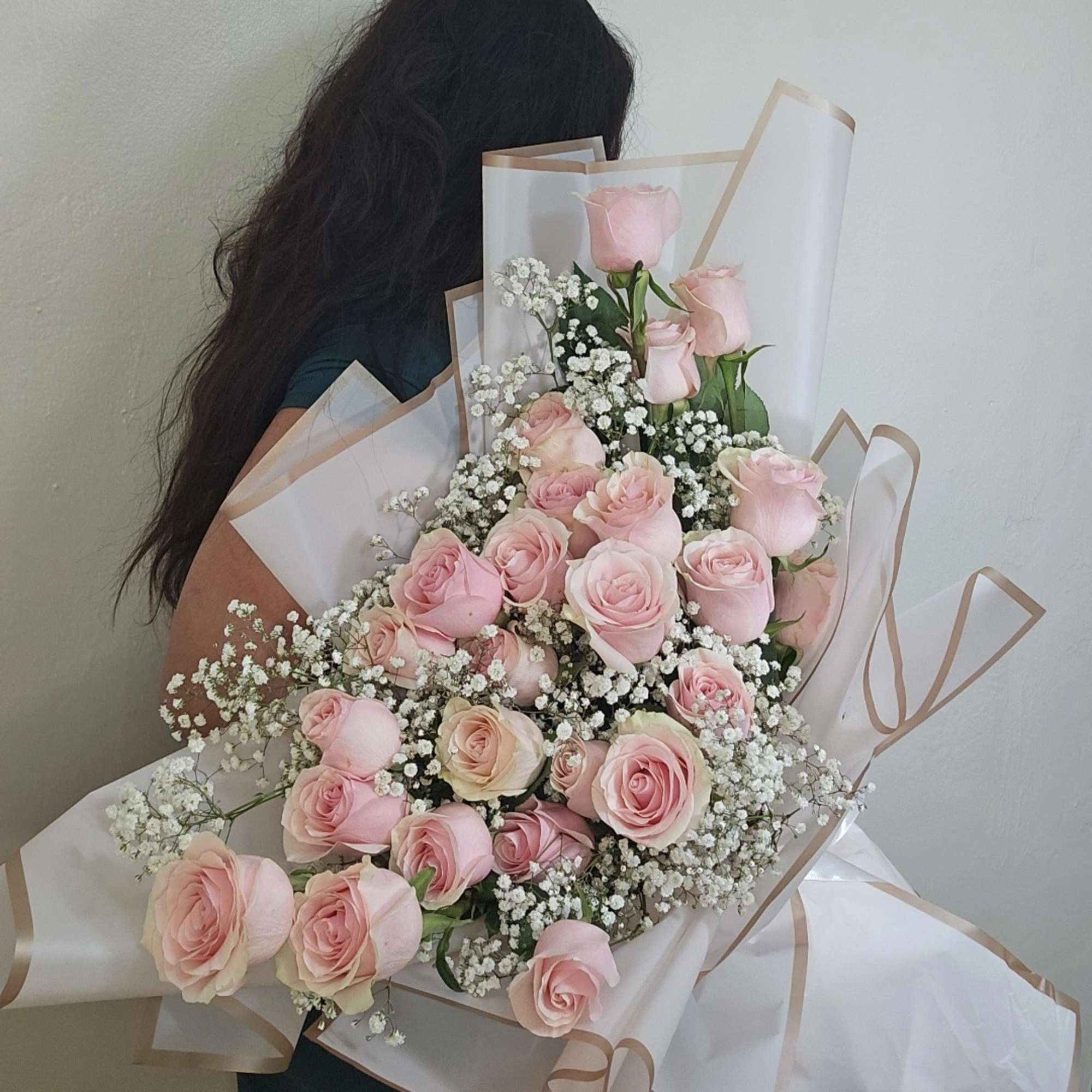 Large bouquet of pale pink roses with white baby's breath in white wrap