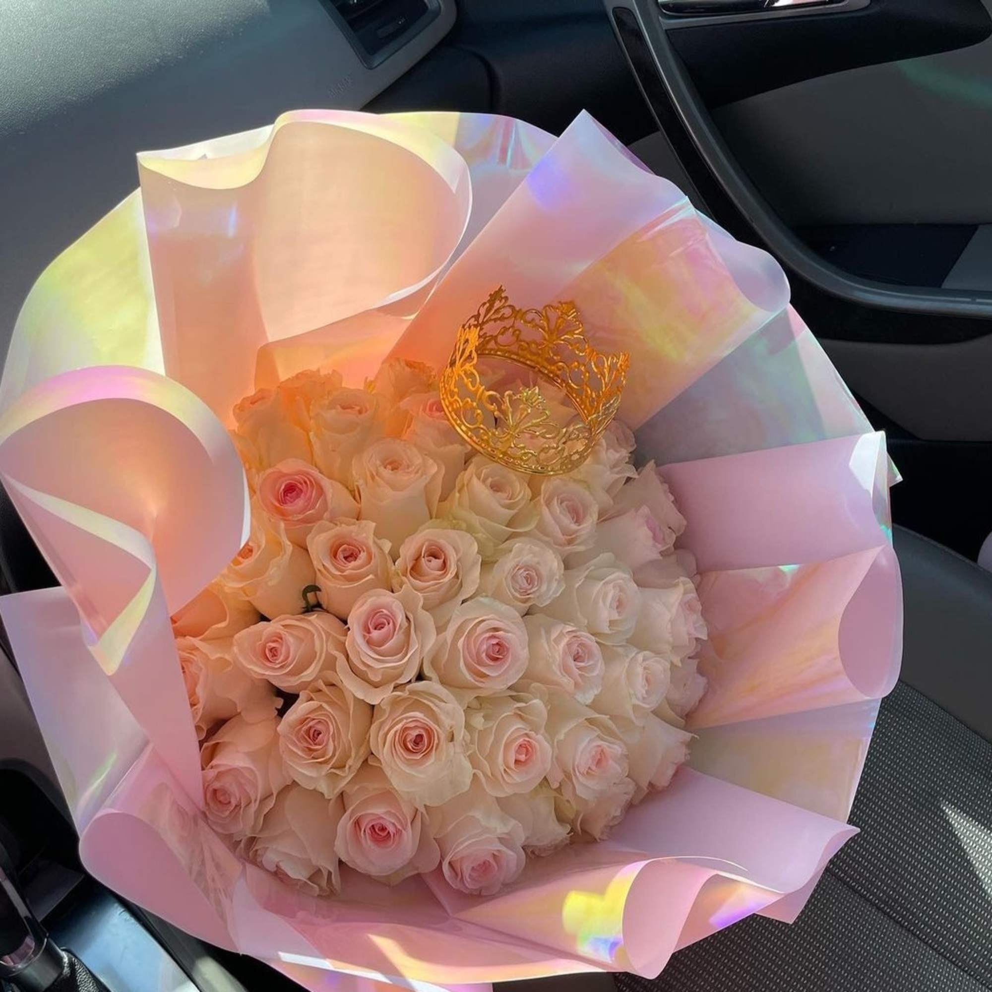 Bouquet of pale pink roses wrapped in iridescent pink paper