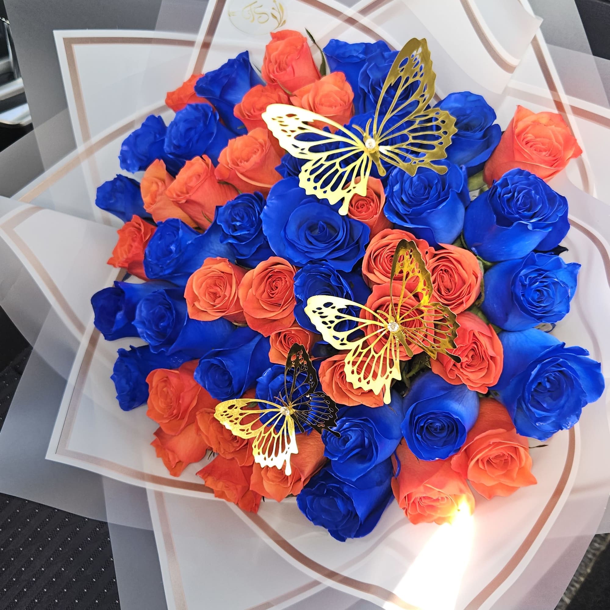Bouquet of blue and orange roses with butterfly decorations, photo 2 of 3