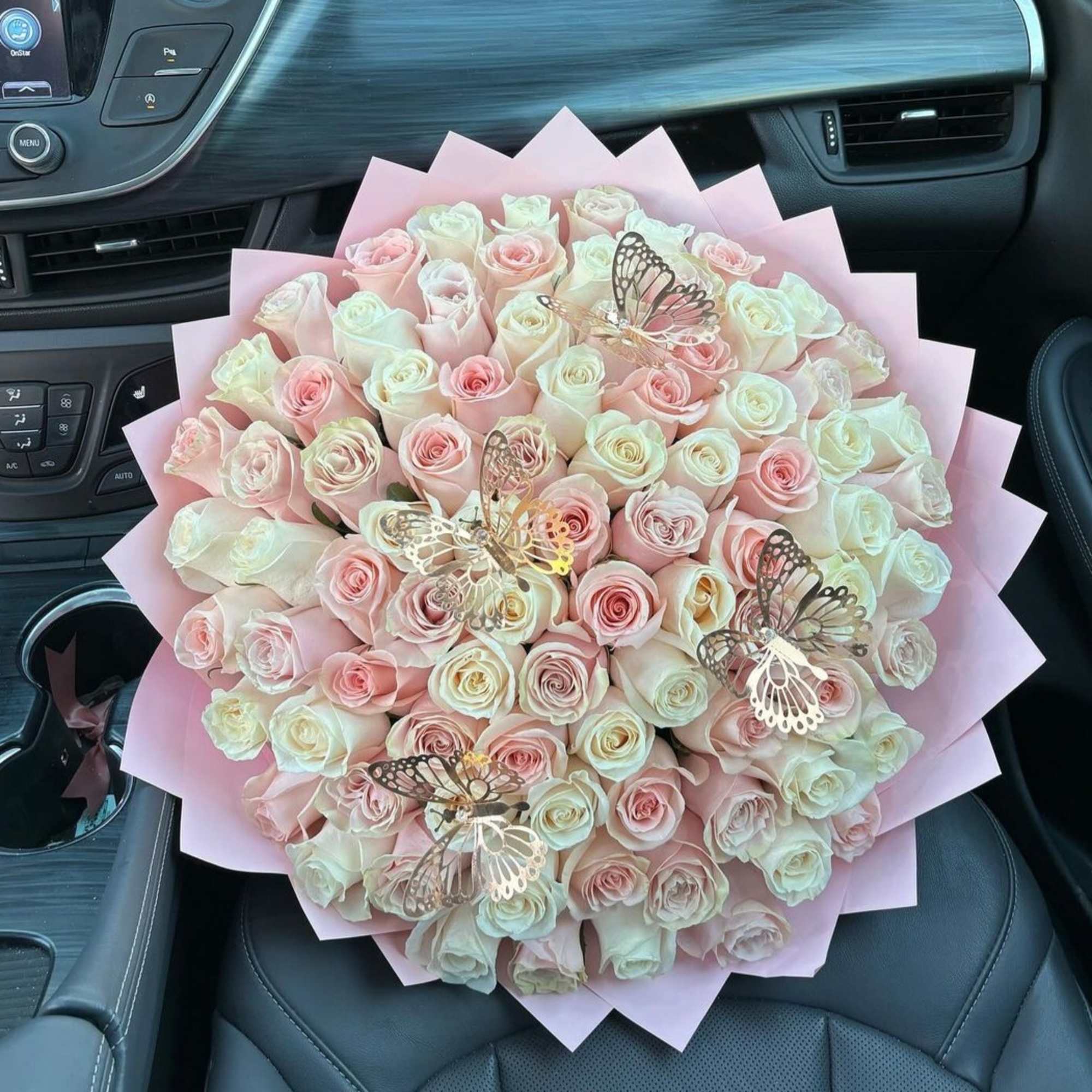 Bouquet of pale pink and white roses with butterfly decorations