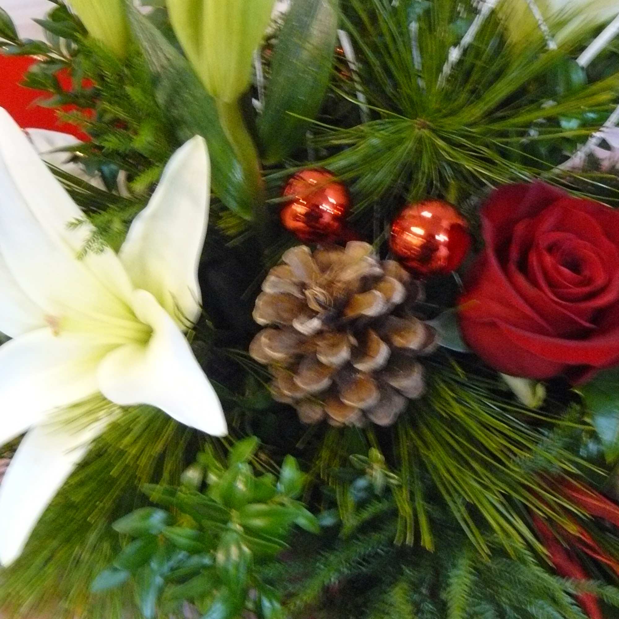 Holiday floral arrangement with a white lily and red rose