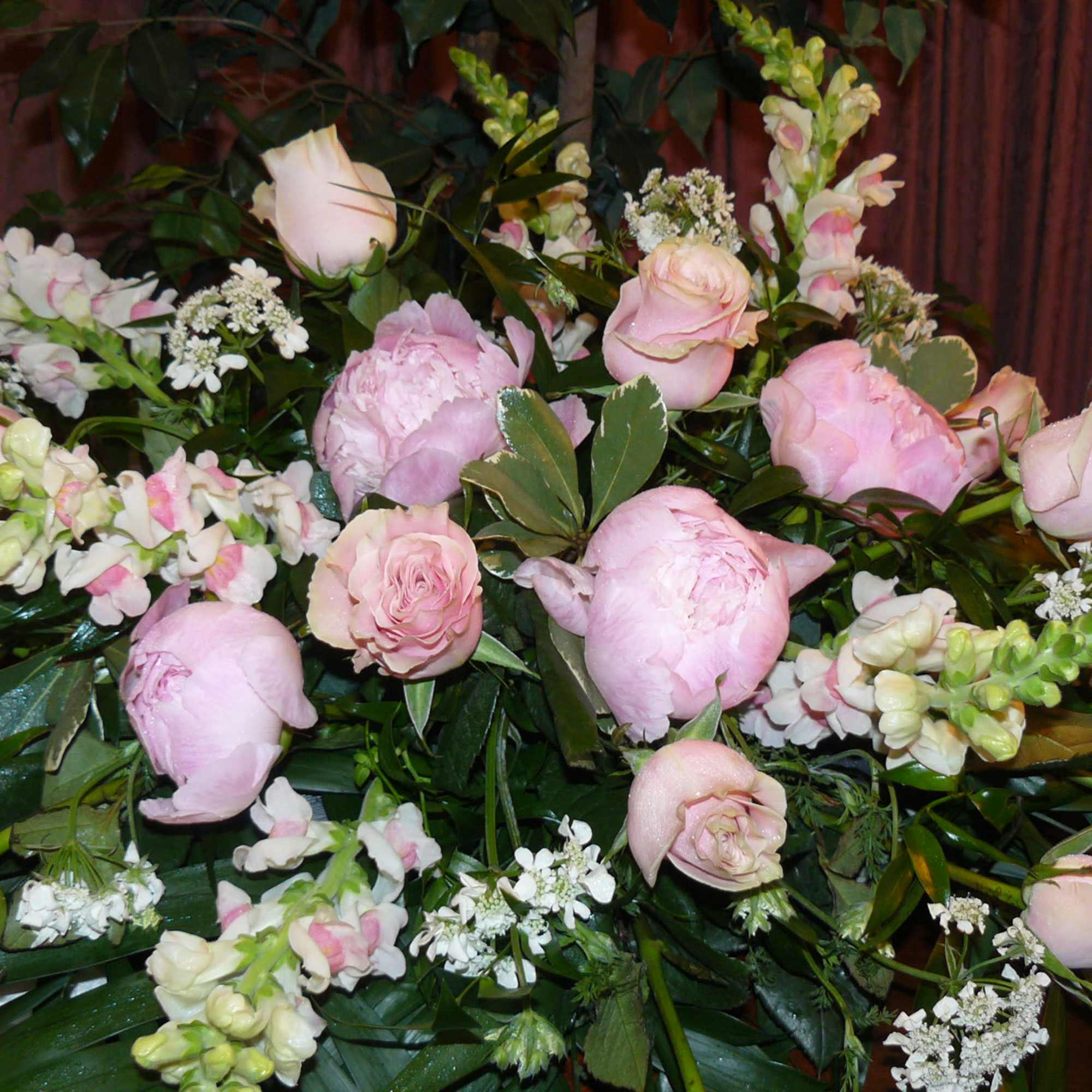 Pink roses and peonies arranged with white filler flowers