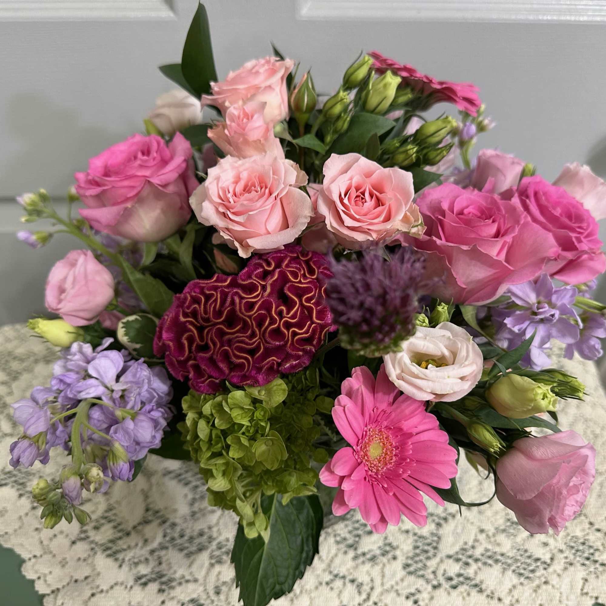Bouquet of pink roses, purple blooms, and a pink gerbera daisy
