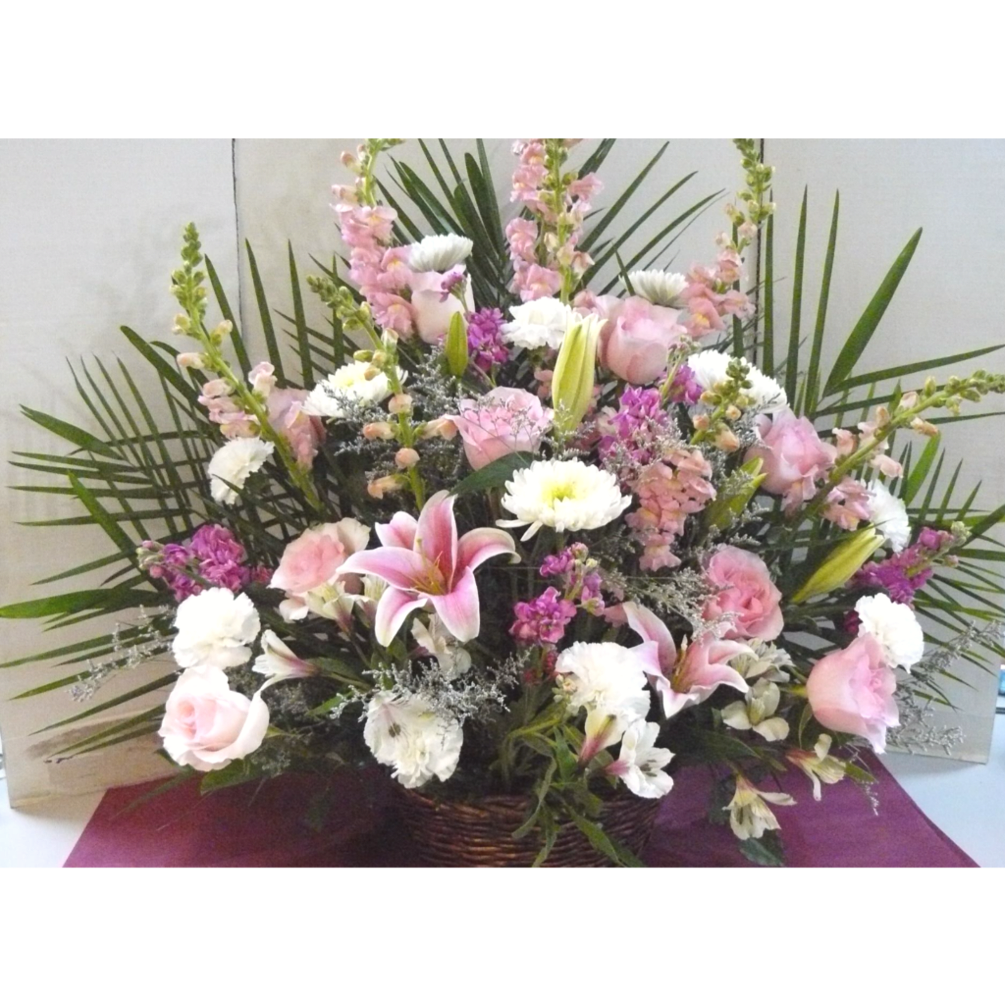 Pink and white mixed flower arrangement in a woven basket