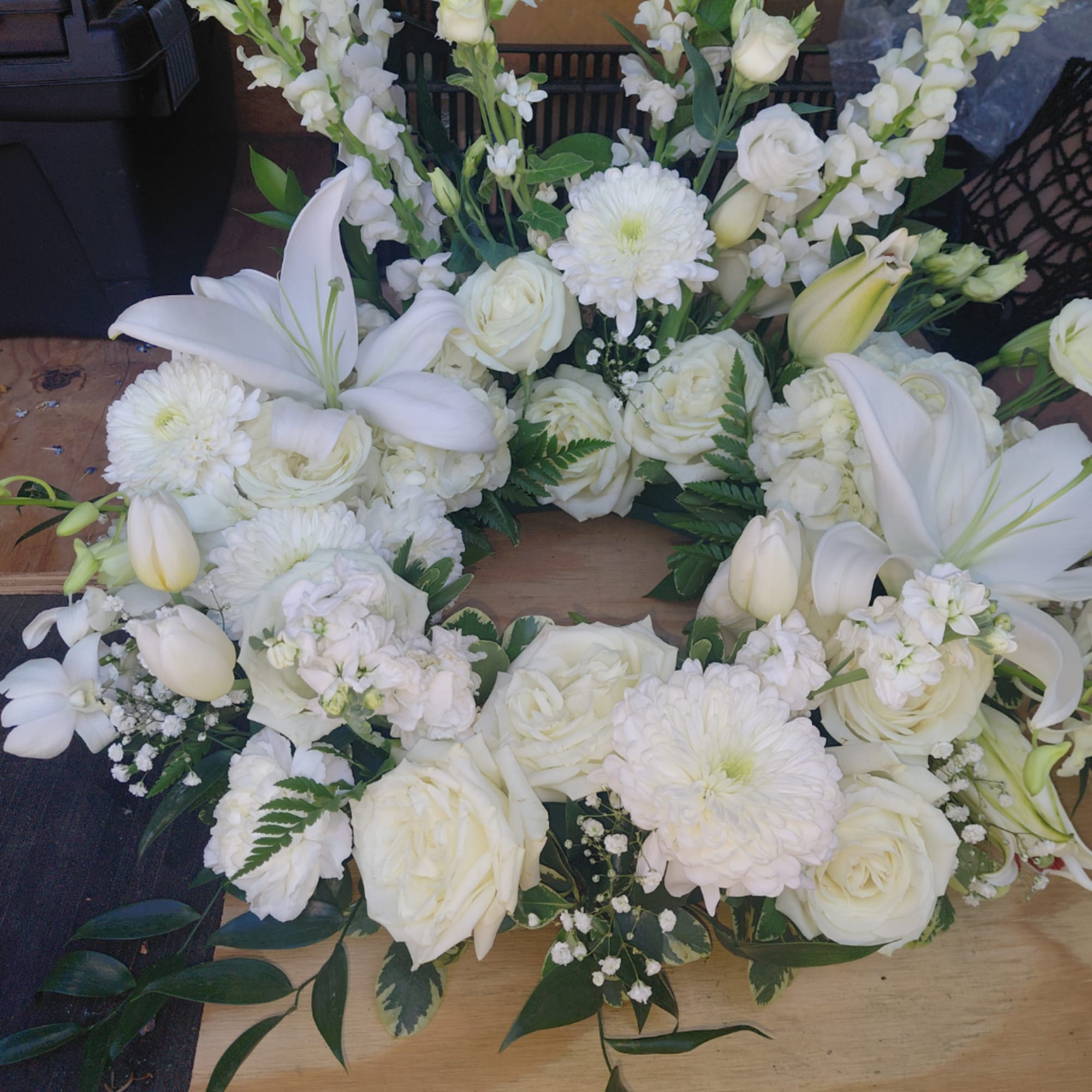 White floral wreath with roses, lilies, and chrysanthemums
