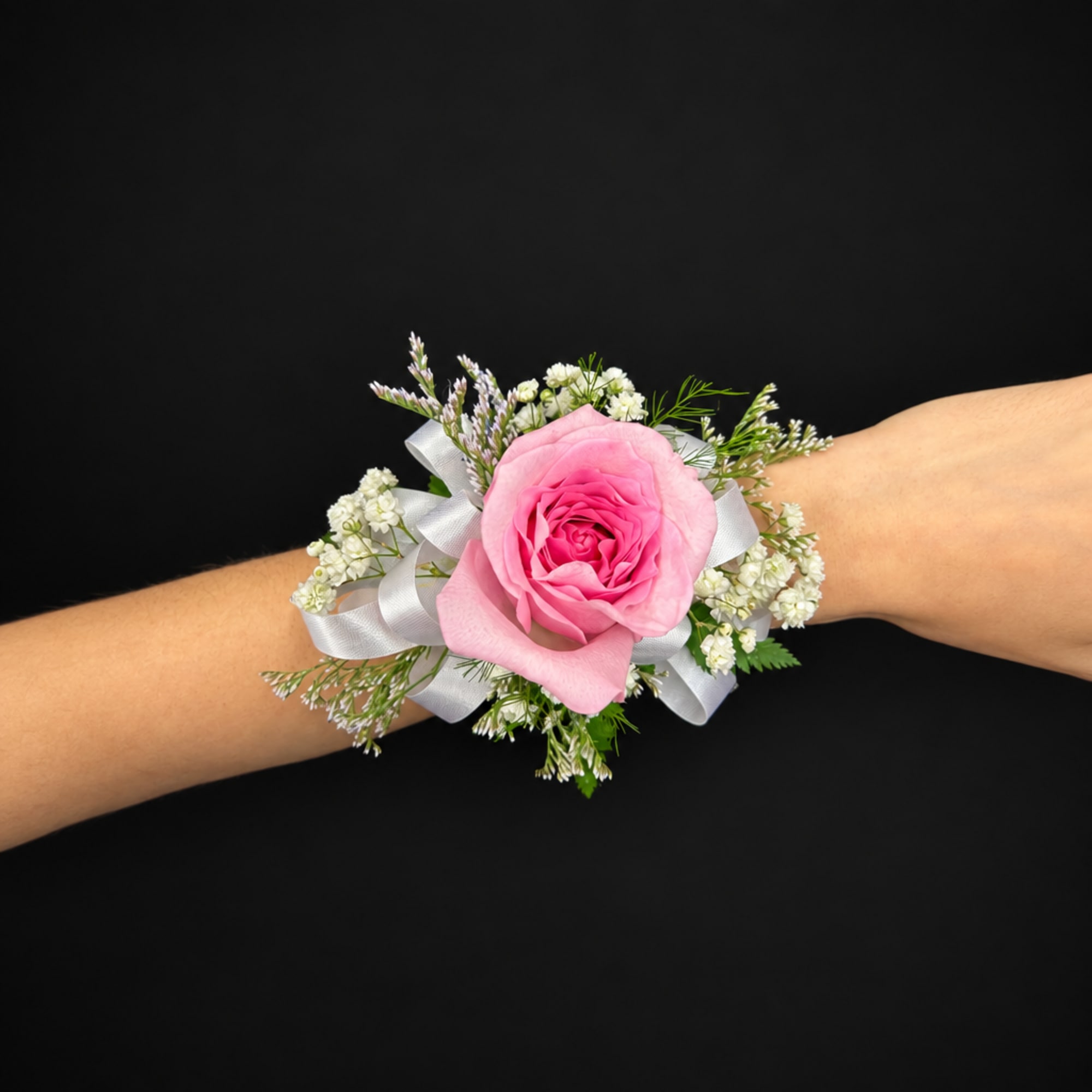 Pink rose wrist corsage with white ribbon and small white flowers