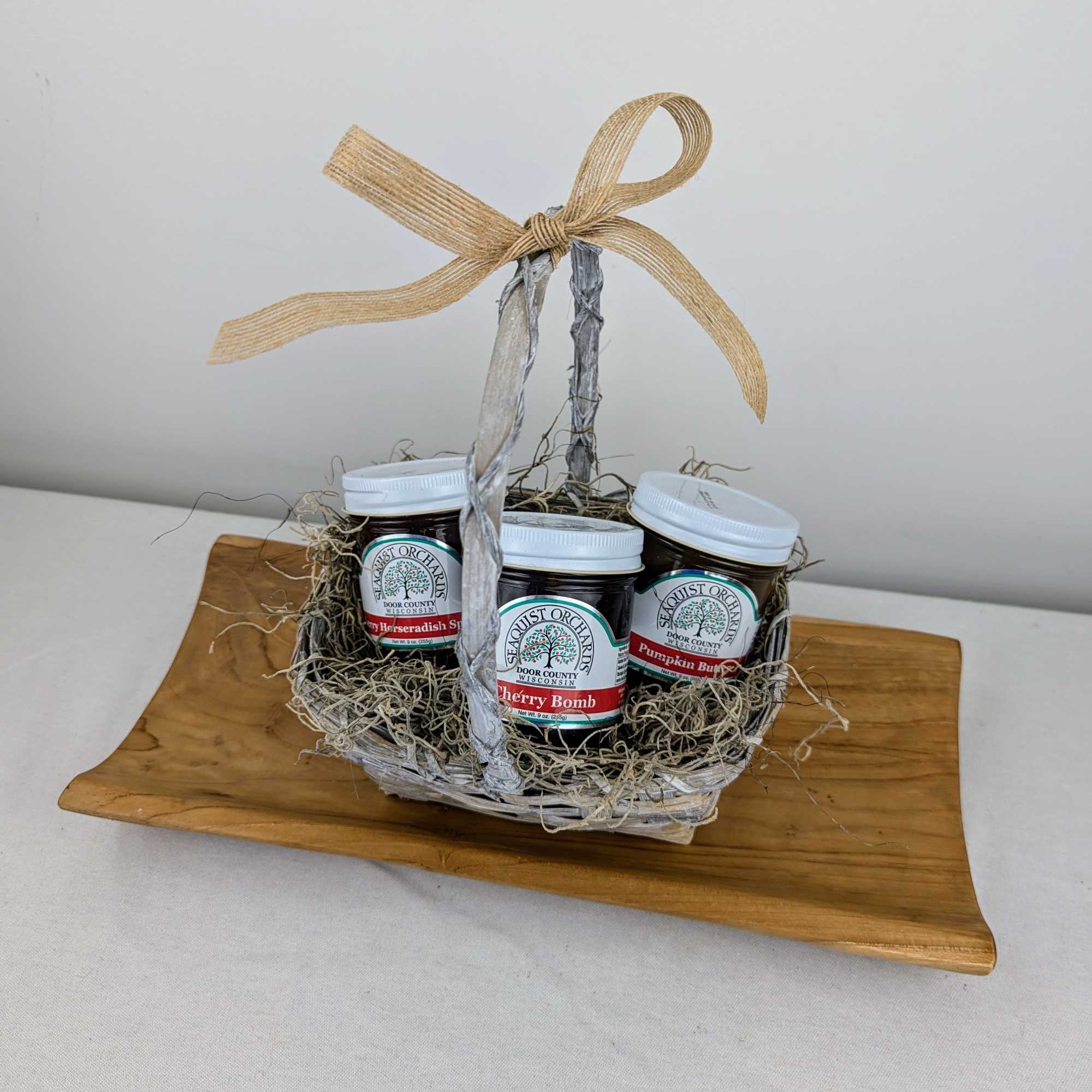 Gift basket with three jam jars on a wooden tray