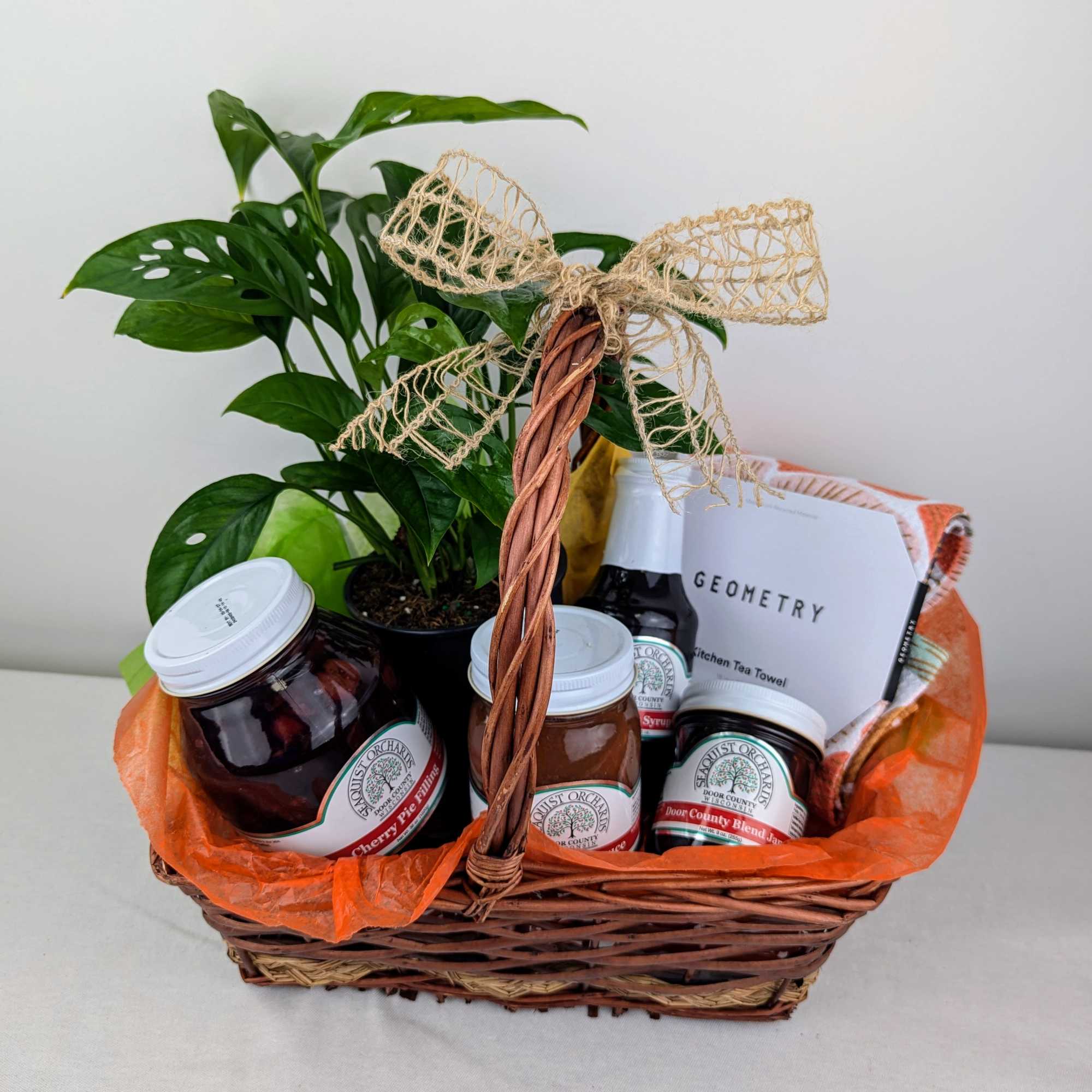 Gift basket with a potted plant, jars, and packaged kitchen items