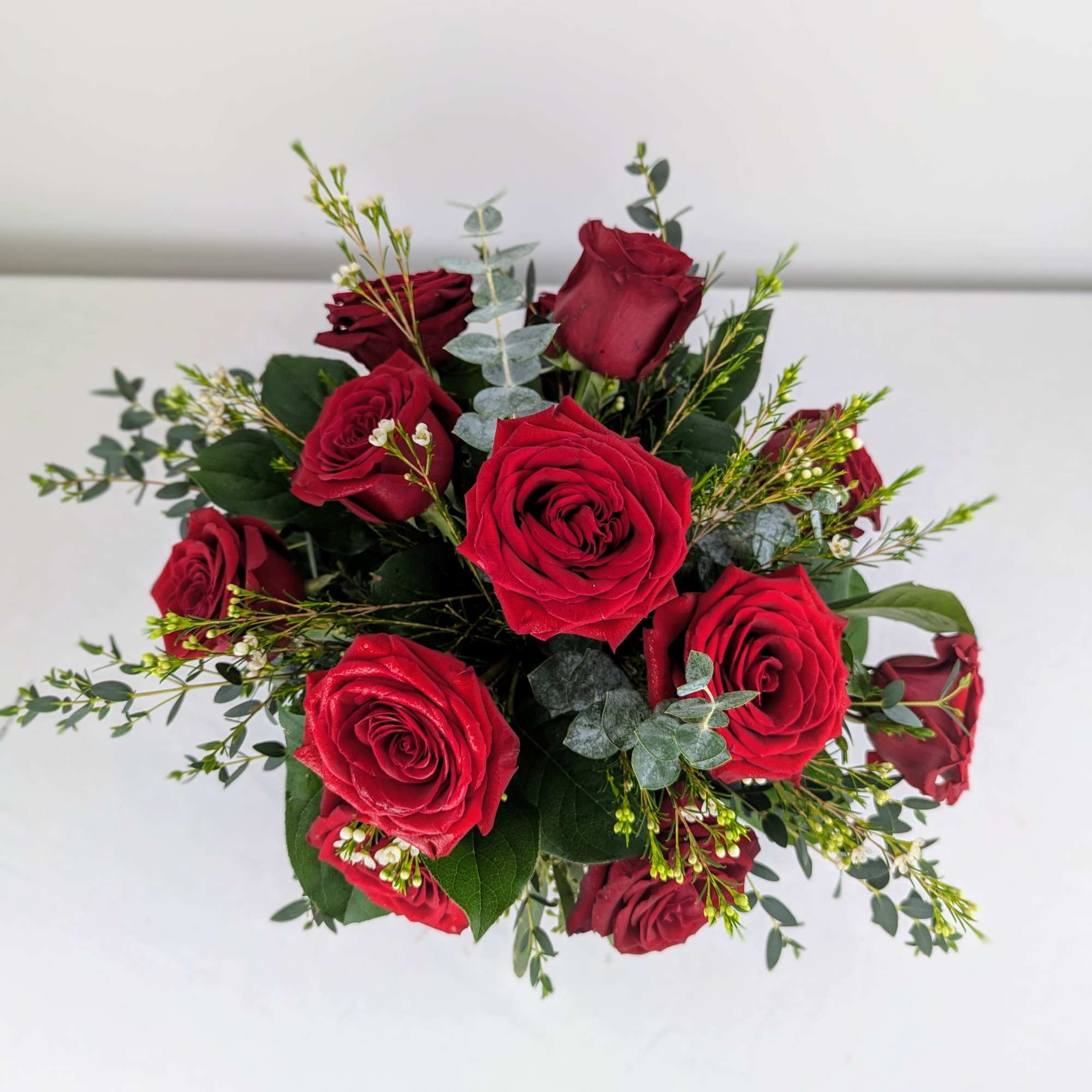 Bouquet of red roses with eucalyptus and small filler flowers