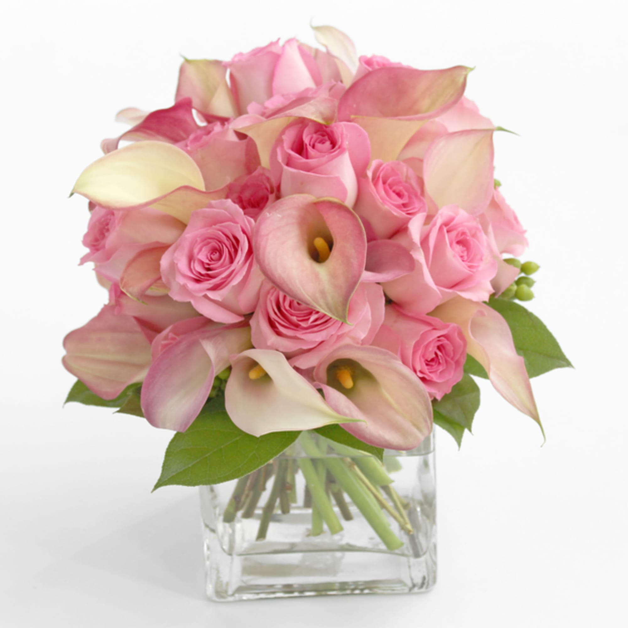 Pink roses and calla lilies arranged in a clear glass vase