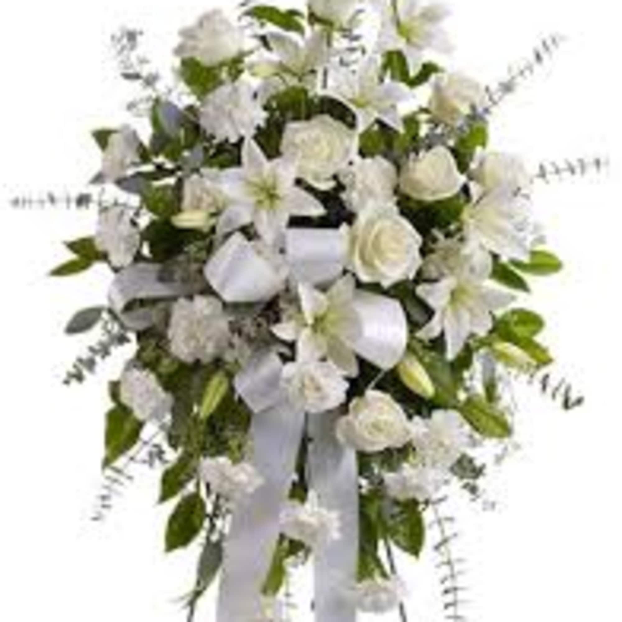 White floral standing spray with lilies and roses on a ribboned easel