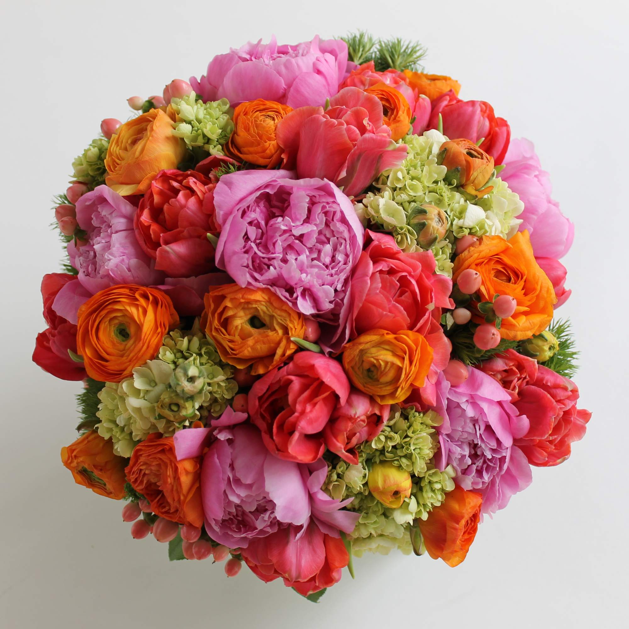 Round bouquet of pink, orange, and red flowers