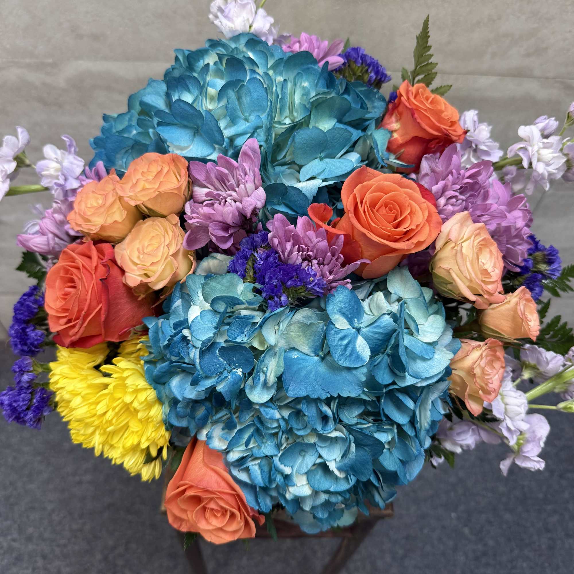 Bouquet of blue hydrangeas with orange and peach roses