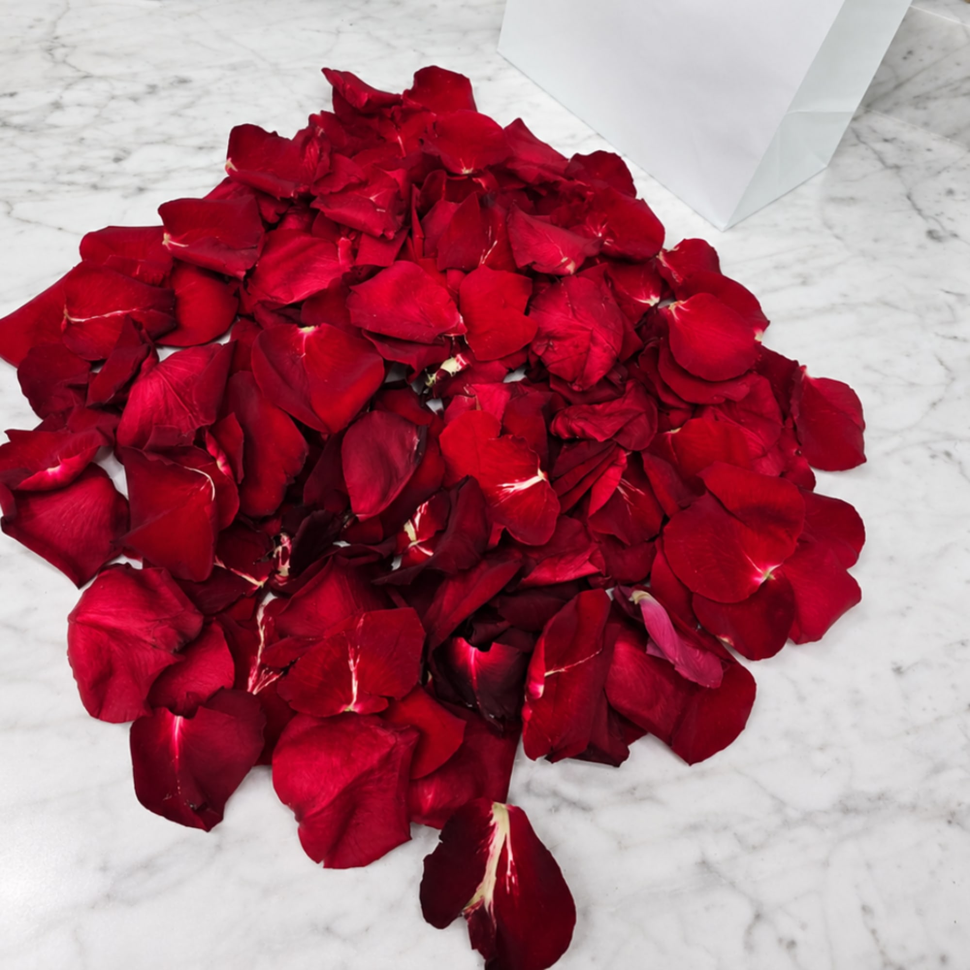 Pile of red rose petals on a marble surface