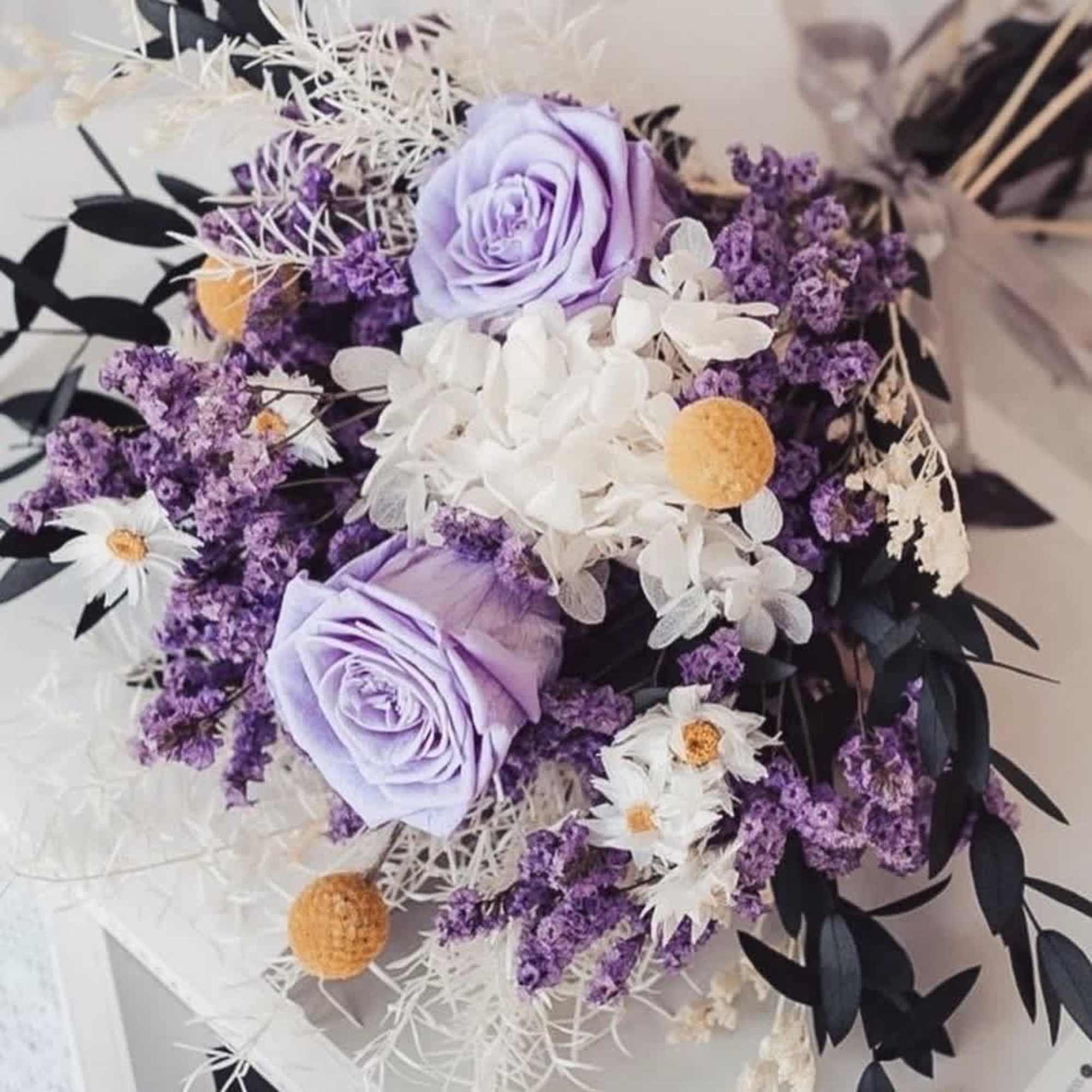 Bouquet of lavender roses, white flowers, and purple filler blooms