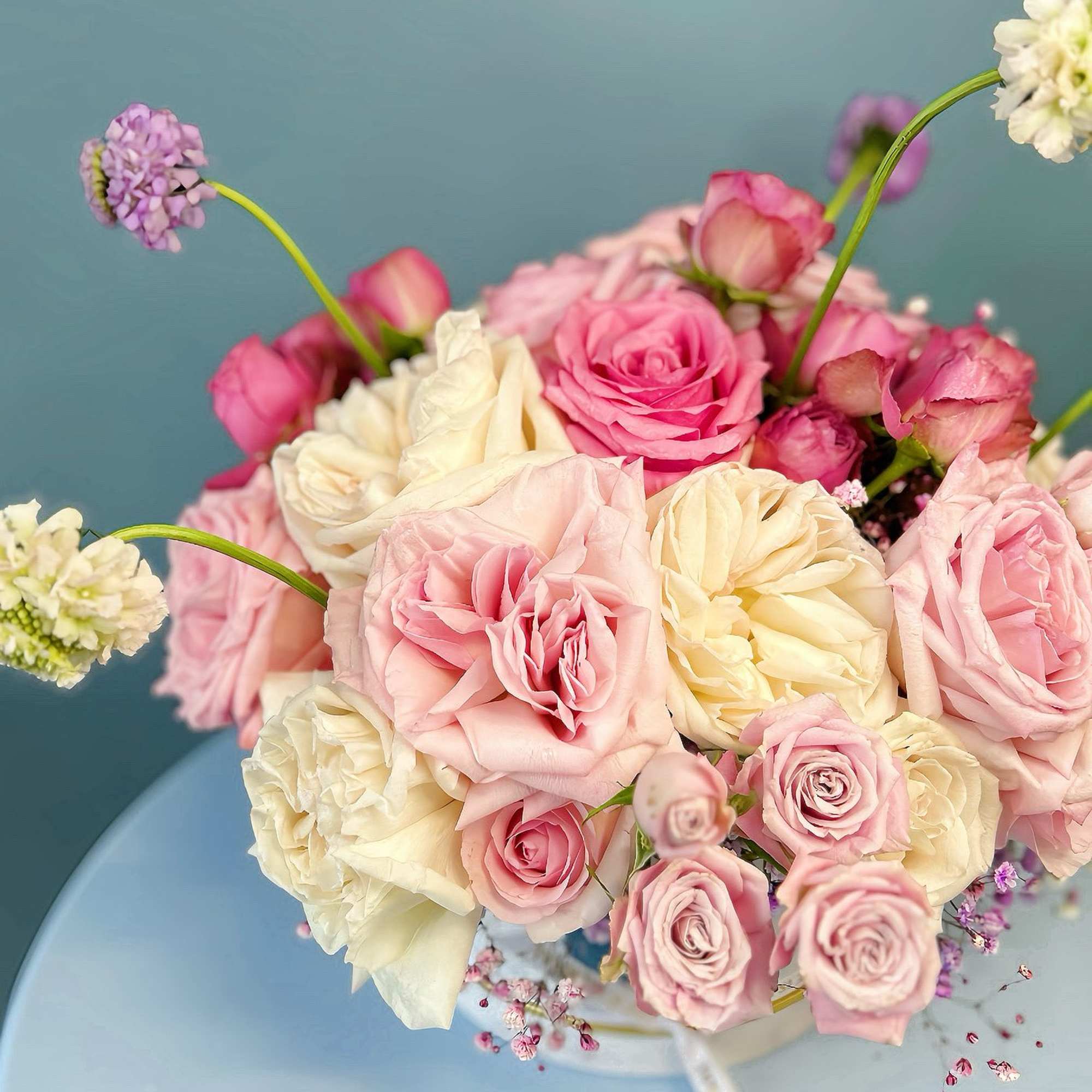 Pink and cream rose bouquet with small purple accent flowers