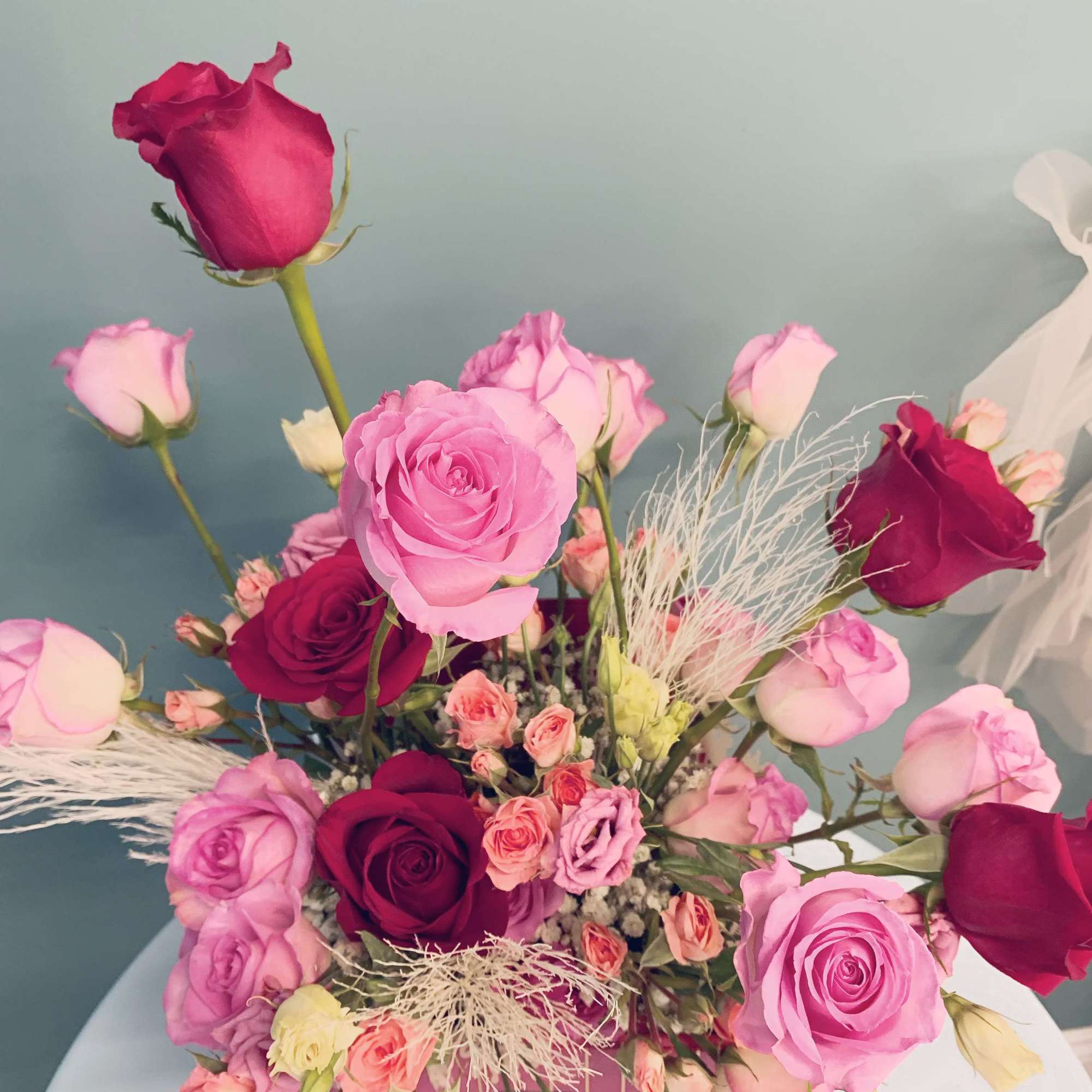 Mixed pink and burgundy roses arranged in a box