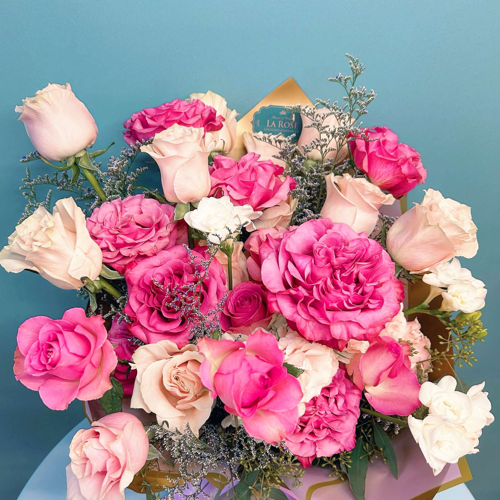 Bouquet of pink and blush roses with small filler flowers