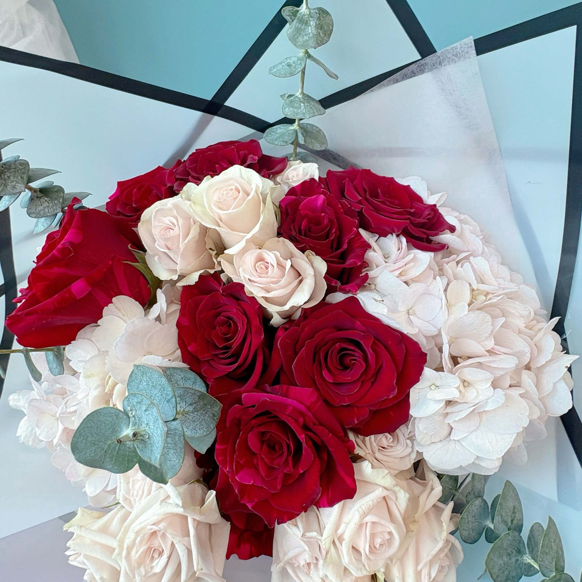 Bouquet of red and white roses with eucalyptus accents