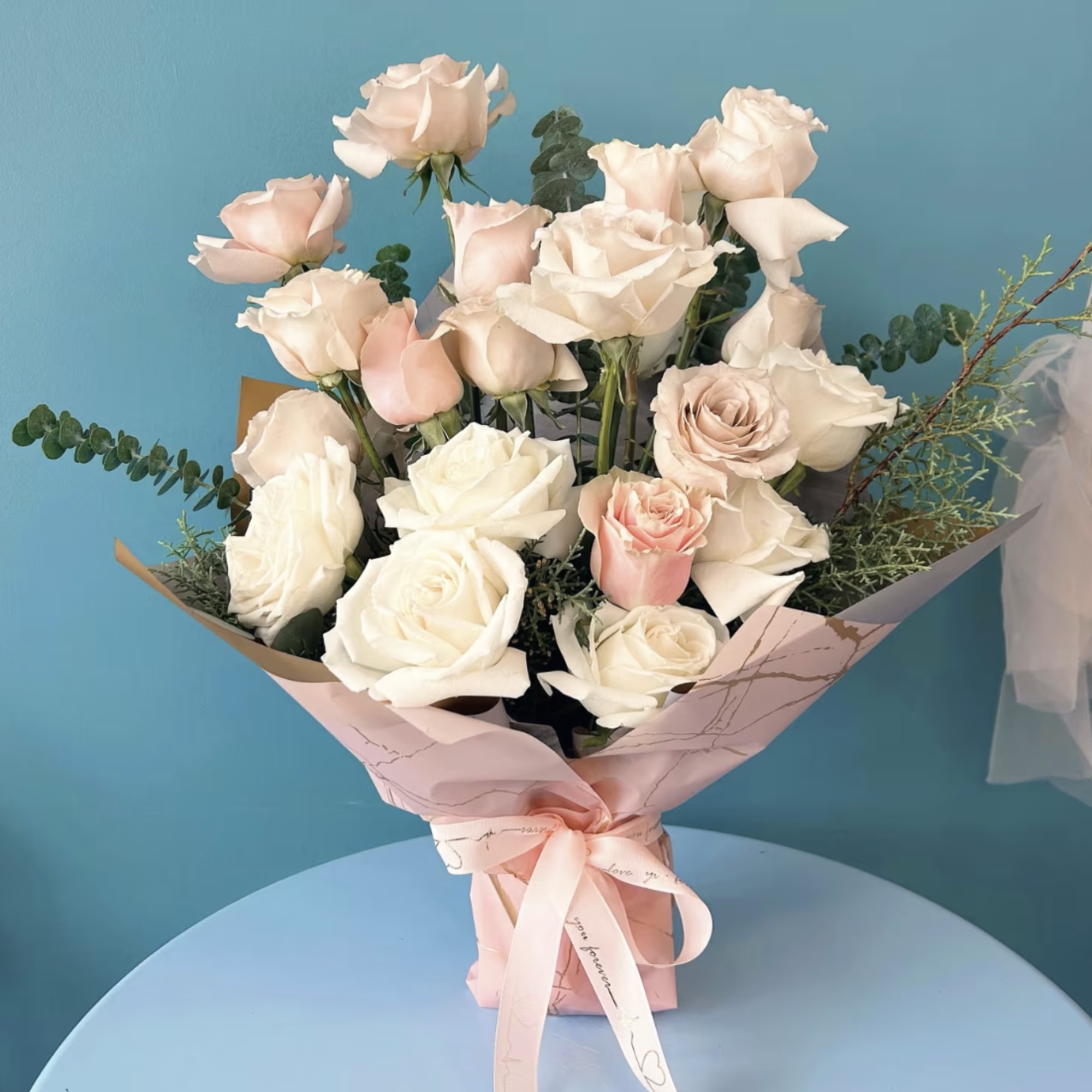 Indulge in the elegance of premium roses, beautifully arranged with complementary floral