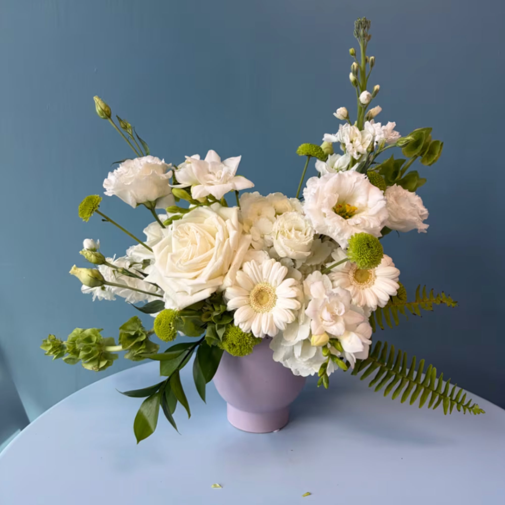 White and pale pink mixed bouquet in a lavender vase
