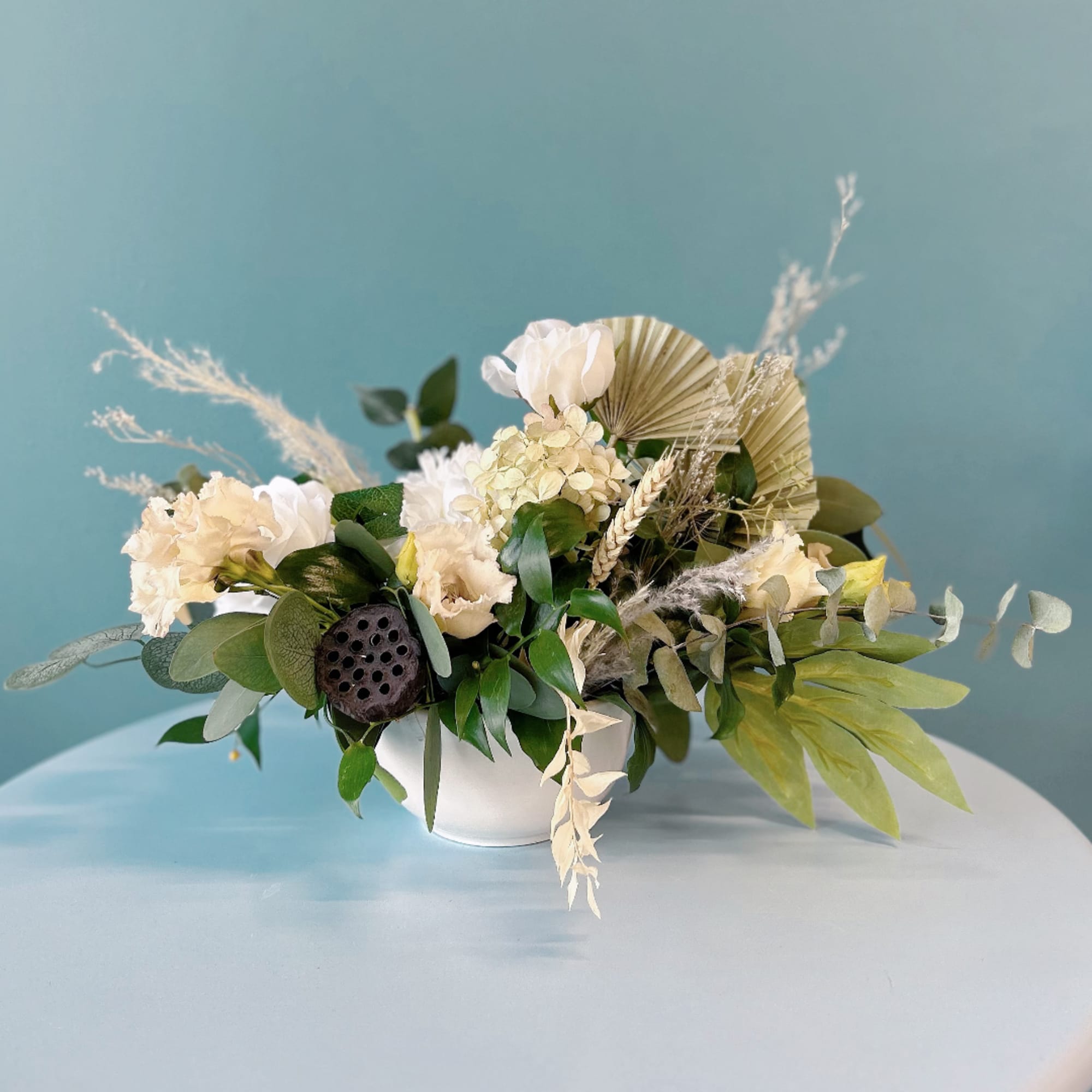 Cream and white floral arrangement in a white bowl vase