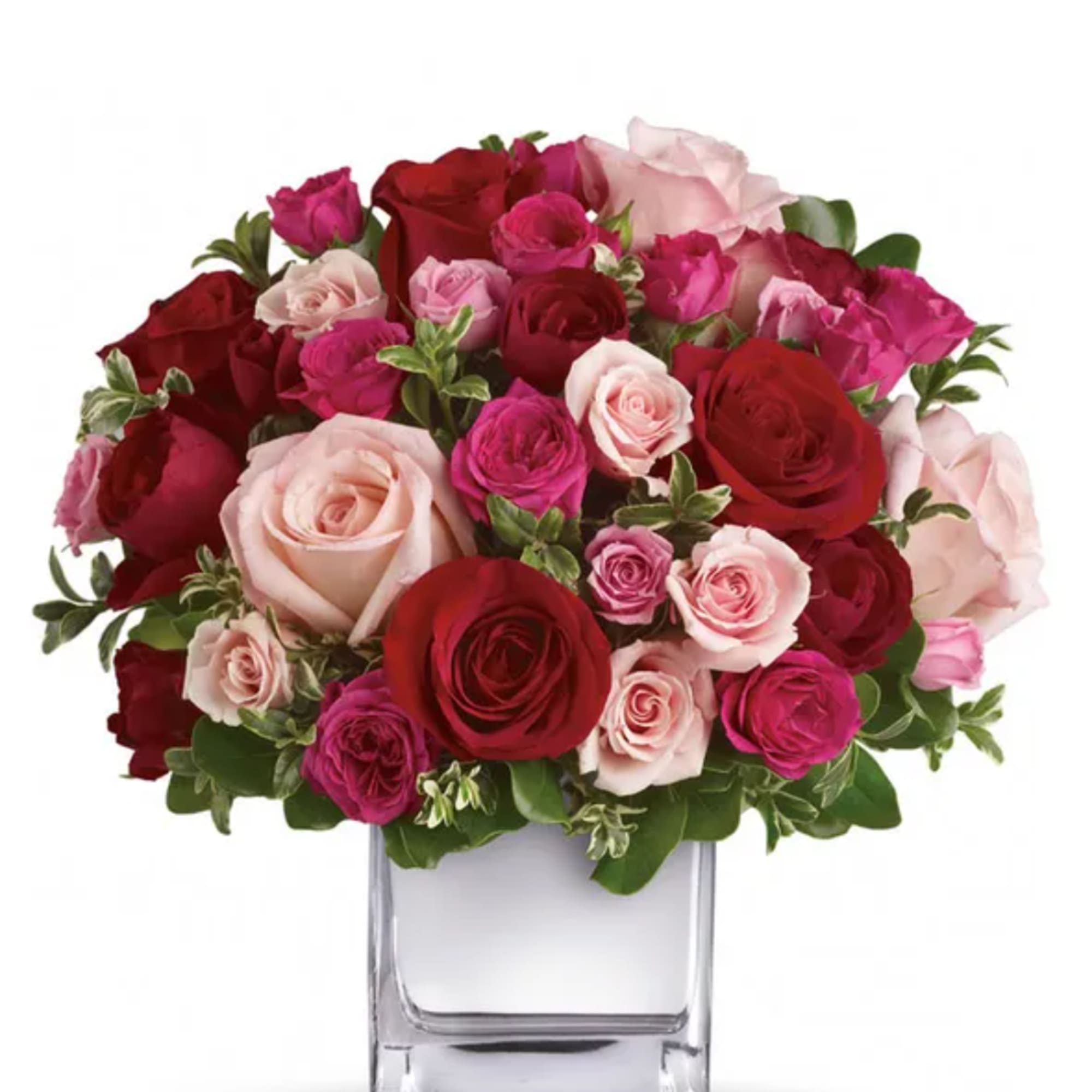 Bouquet of red, pink, and blush roses in a clear glass vase