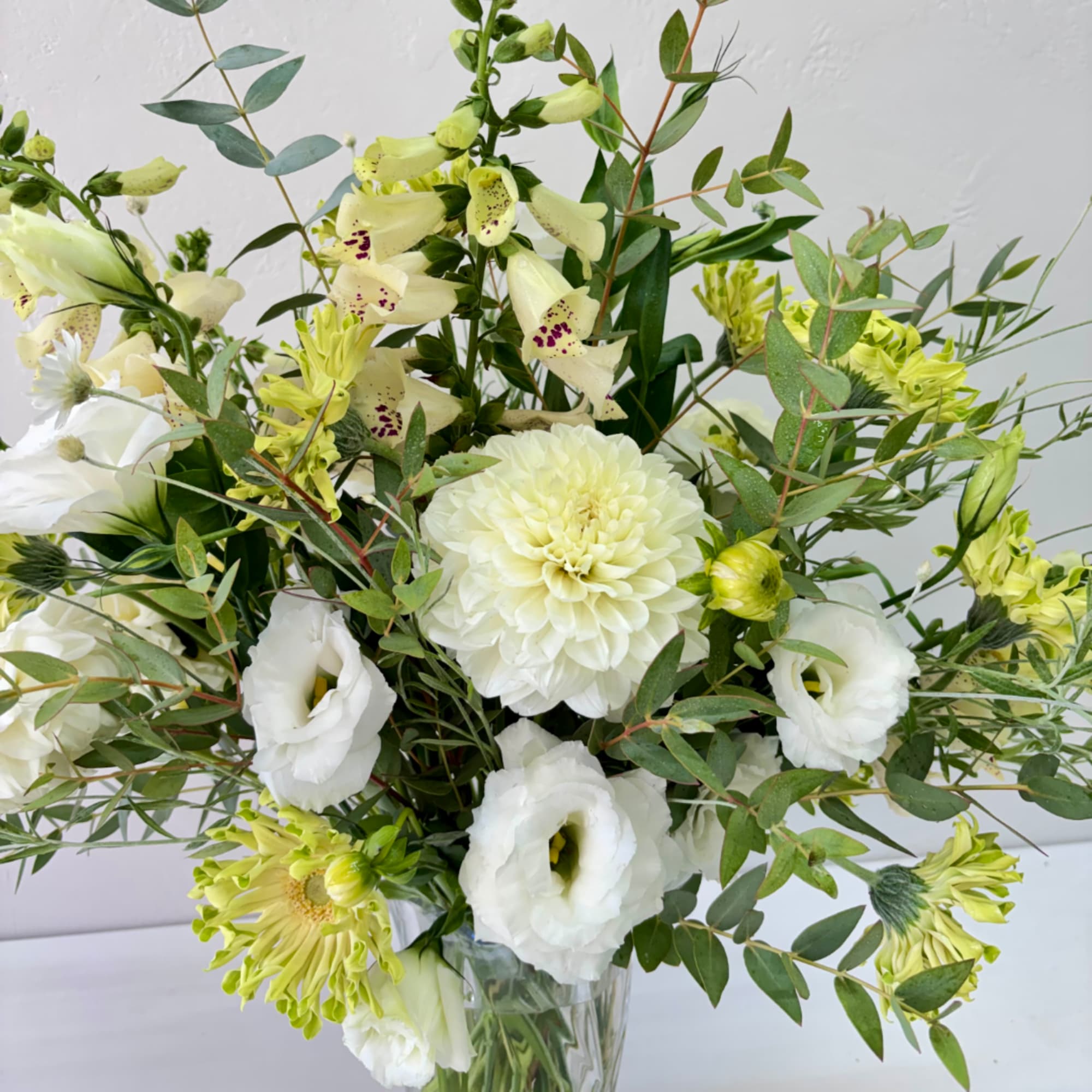 White and pale green floral arrangement in a clear glass vase, photo 2 of 2