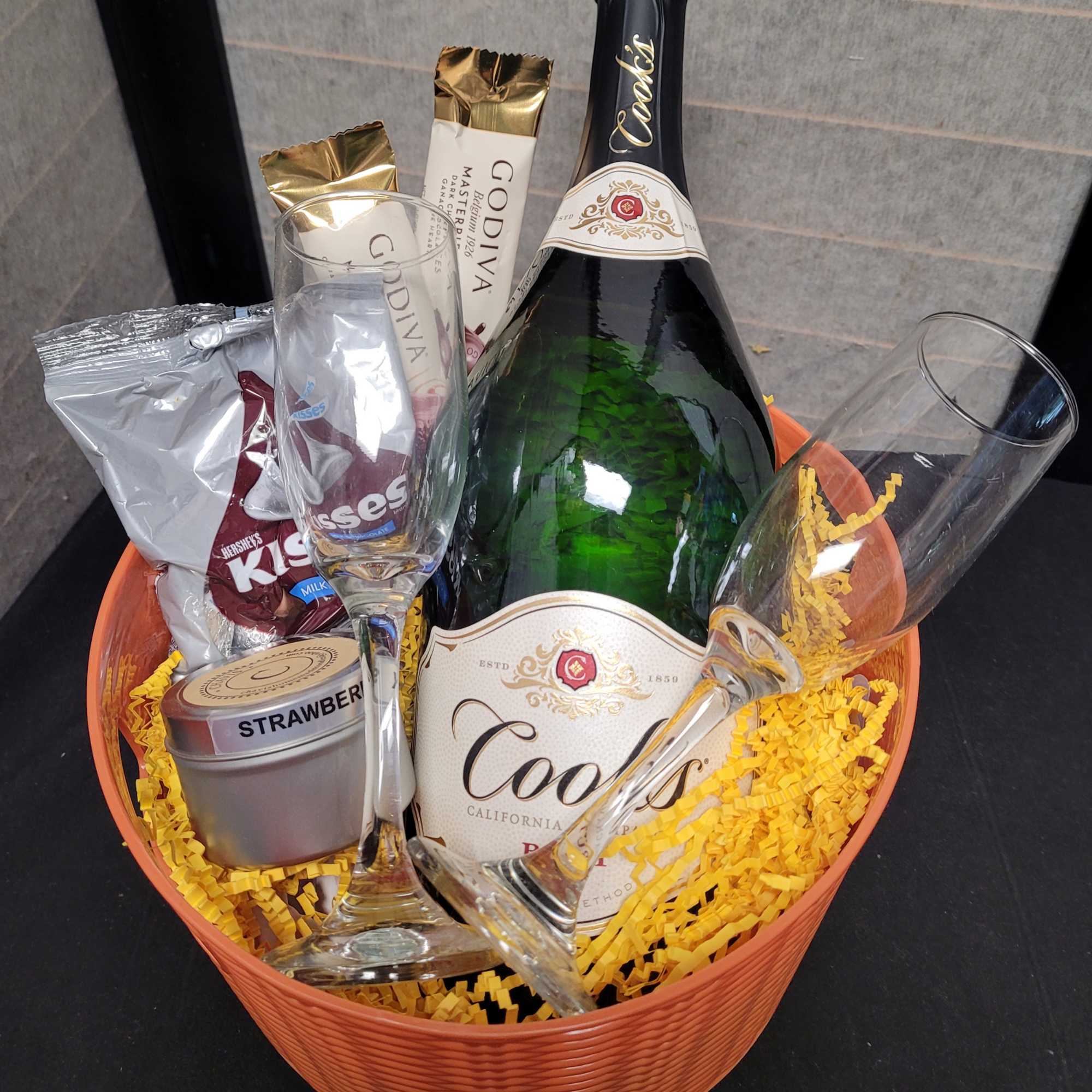 Gift basket with champagne, chocolates, and two flutes